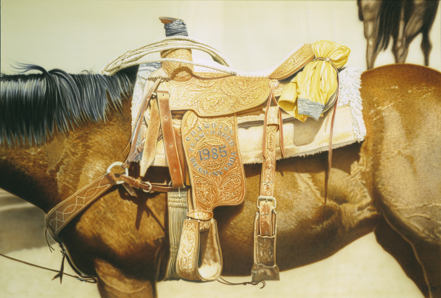Rolled up yellow rain jacket tied to the back of a saddle on a horse.