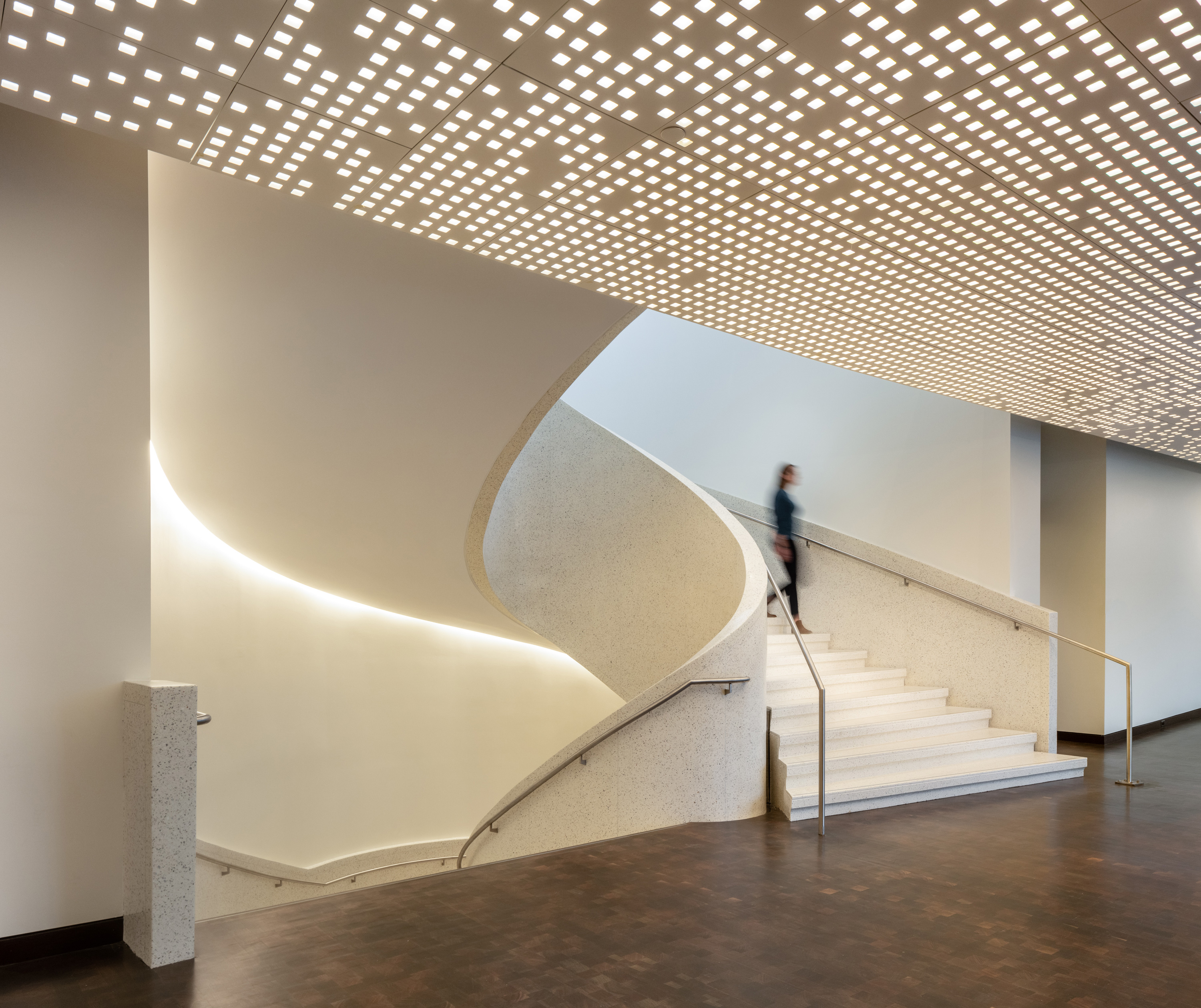 Woman walking down spiral staircase in new Martin Building
