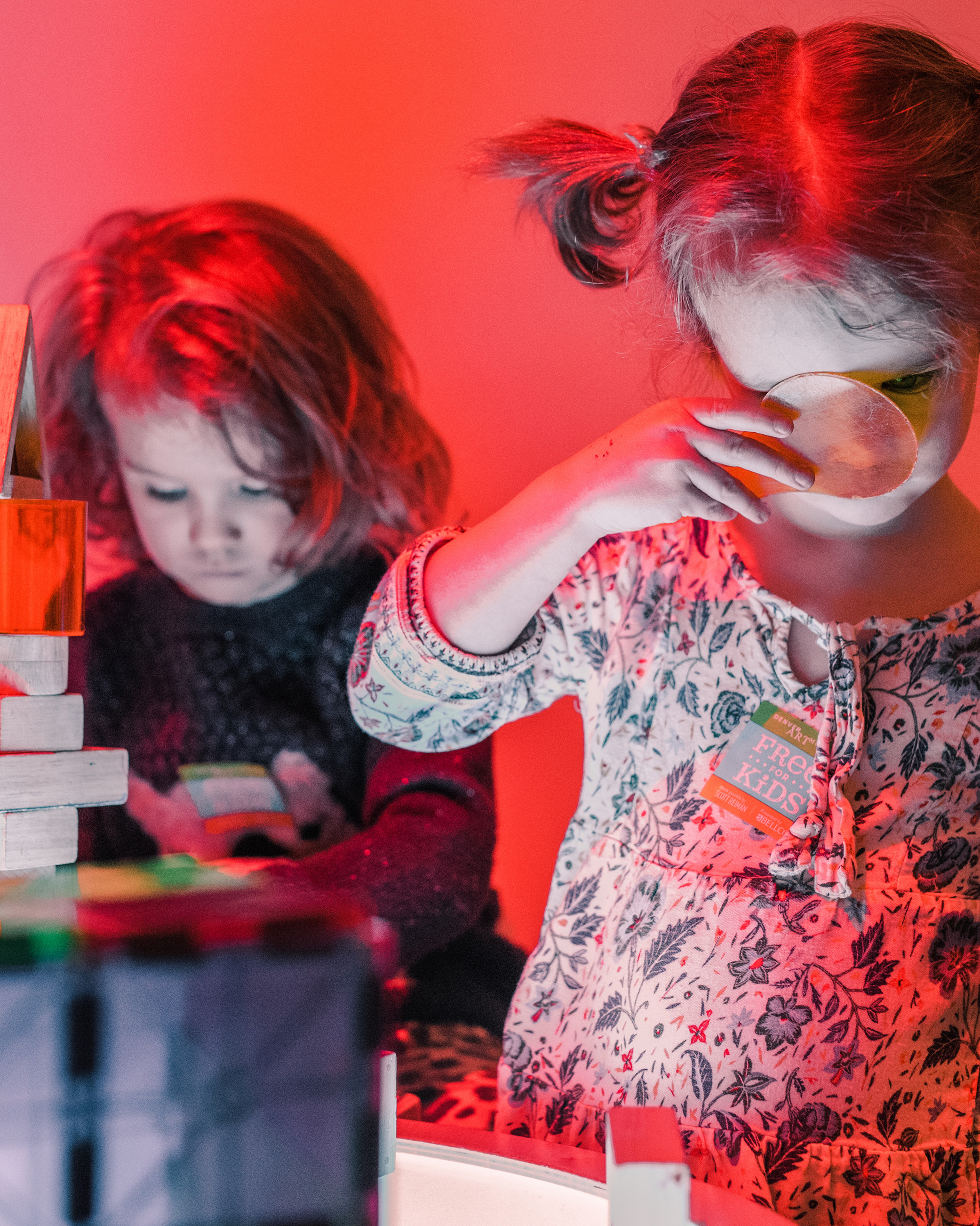 Two little girls looking through colored gels