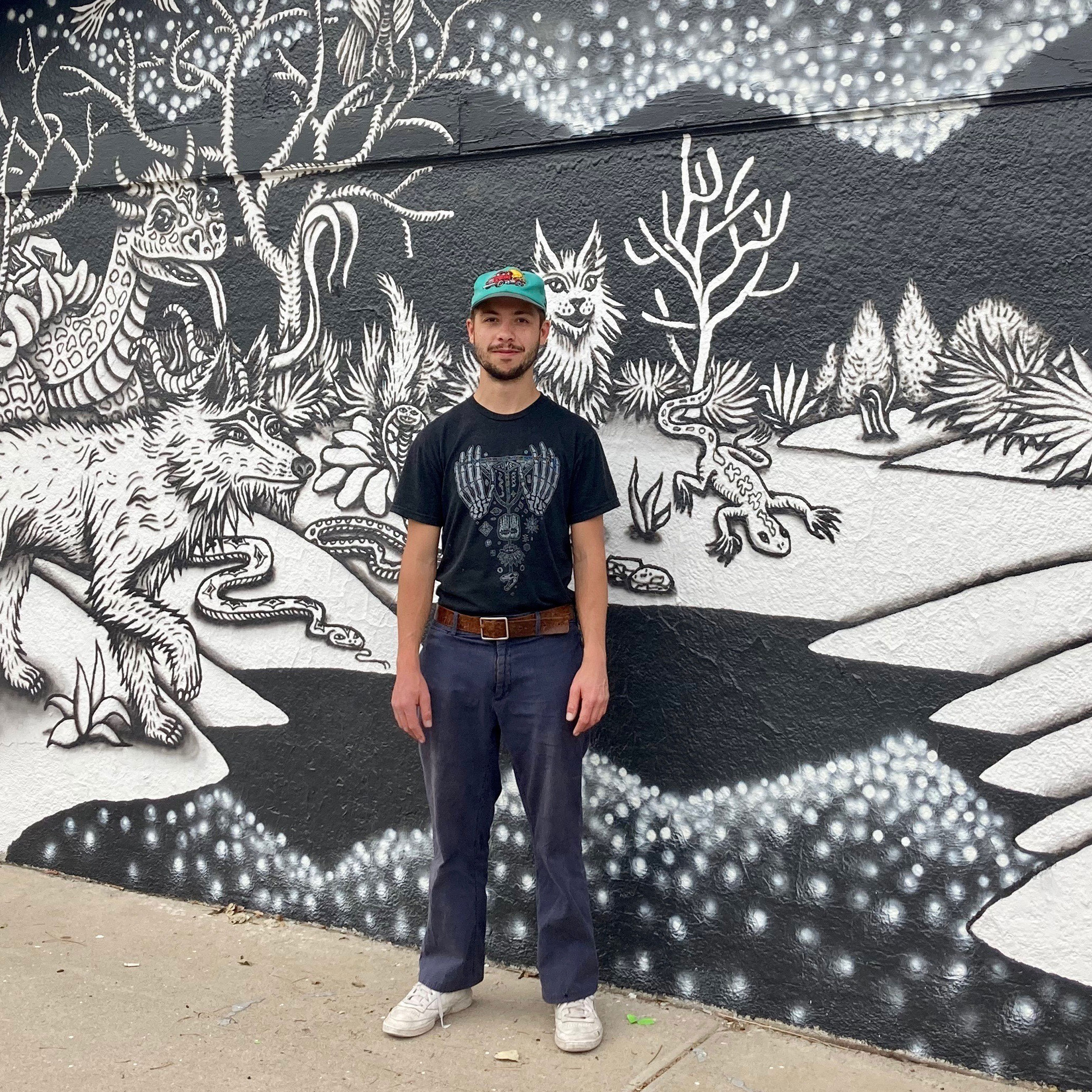 Justin Camilli standing in front of a mural he made