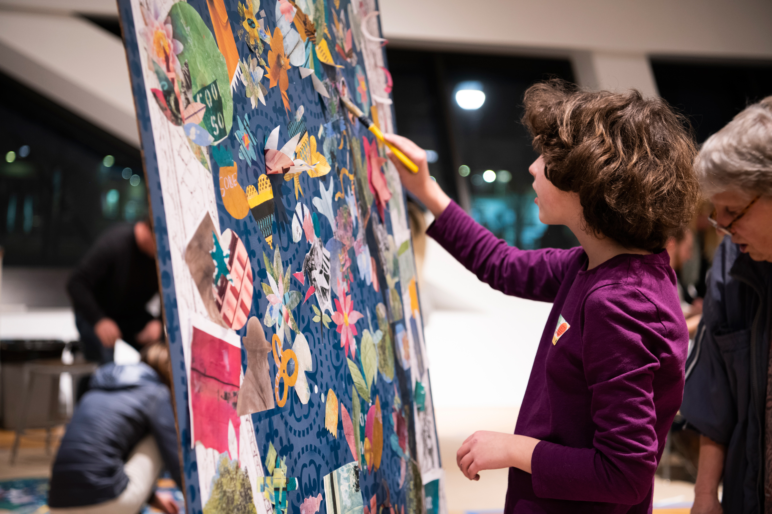 Kid standing and working on an artwork on an easel