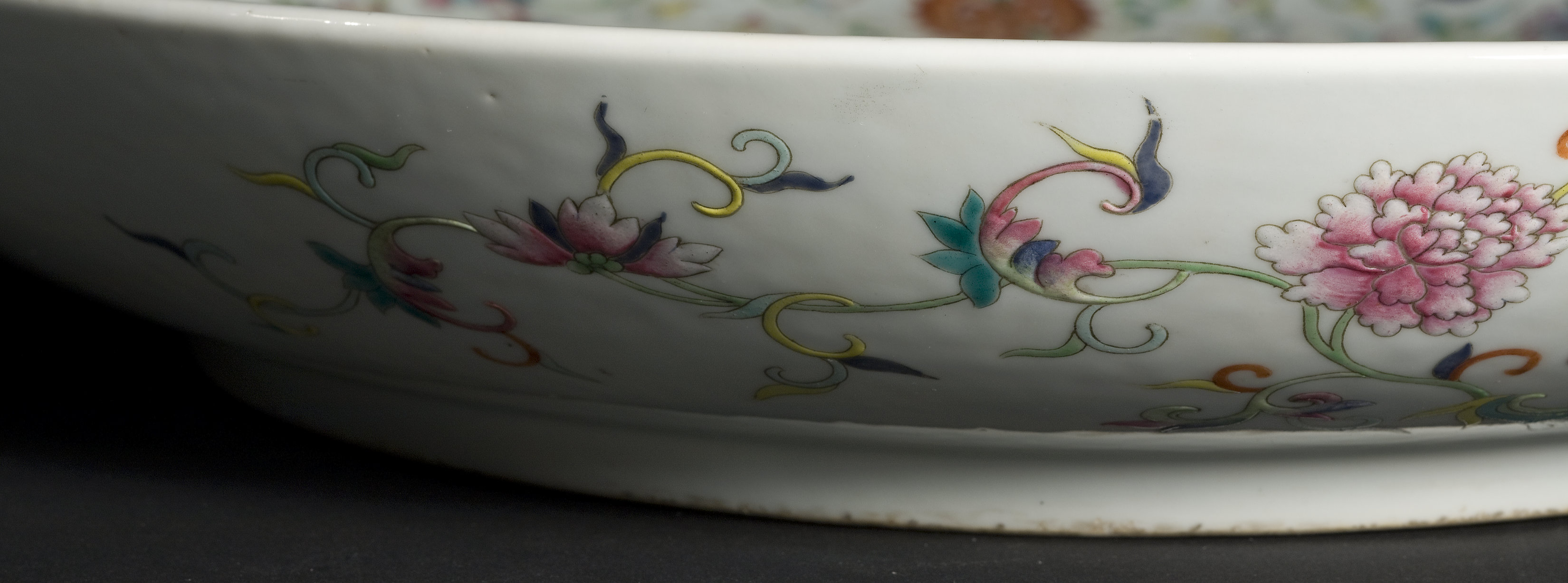The edge of a highly decorative porcelain dish, of clearly high quality.