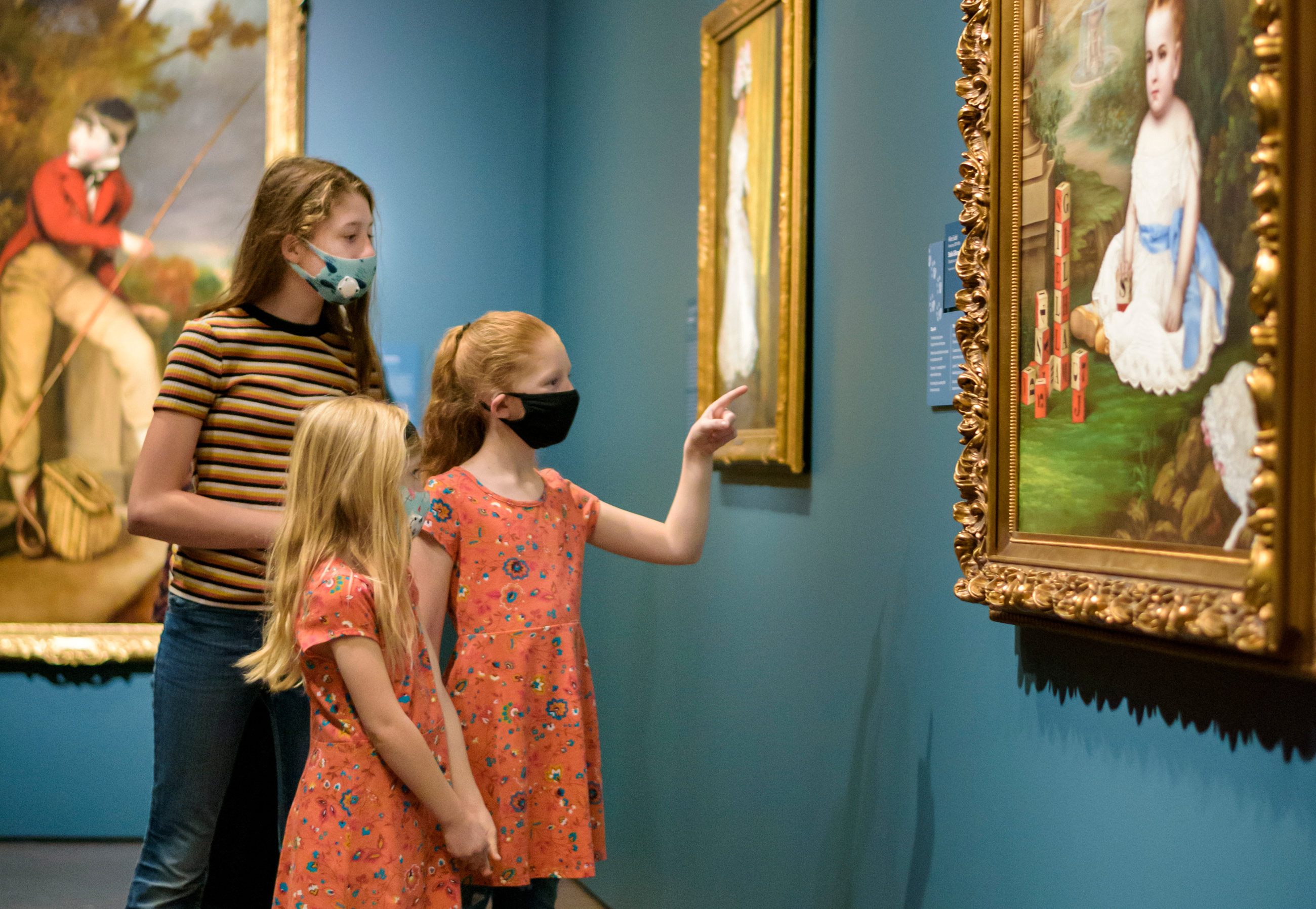 A family searches for clues in the paintings as they play a game created by the museum in the galleries