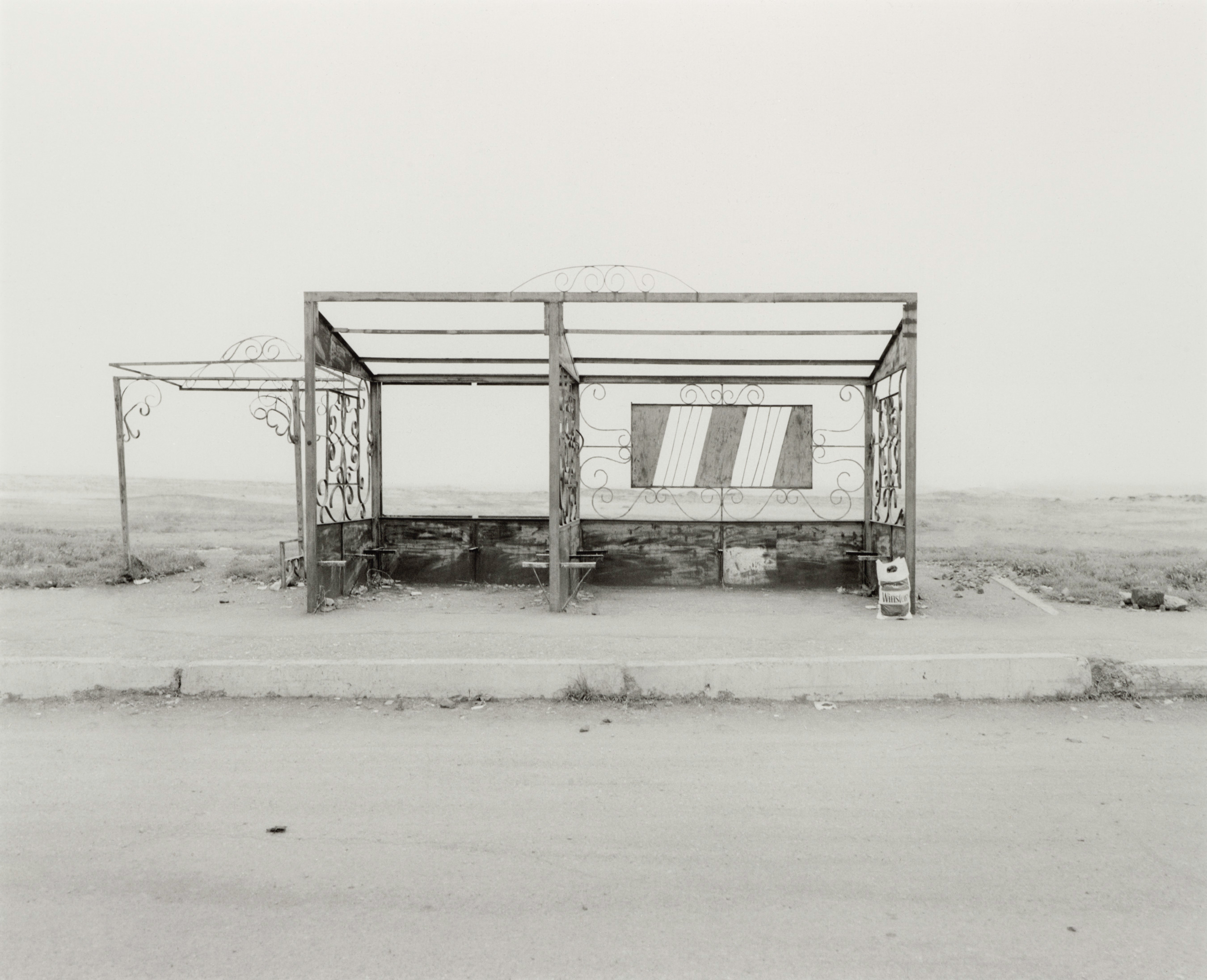 Old photo of a bus stop in a remote area.