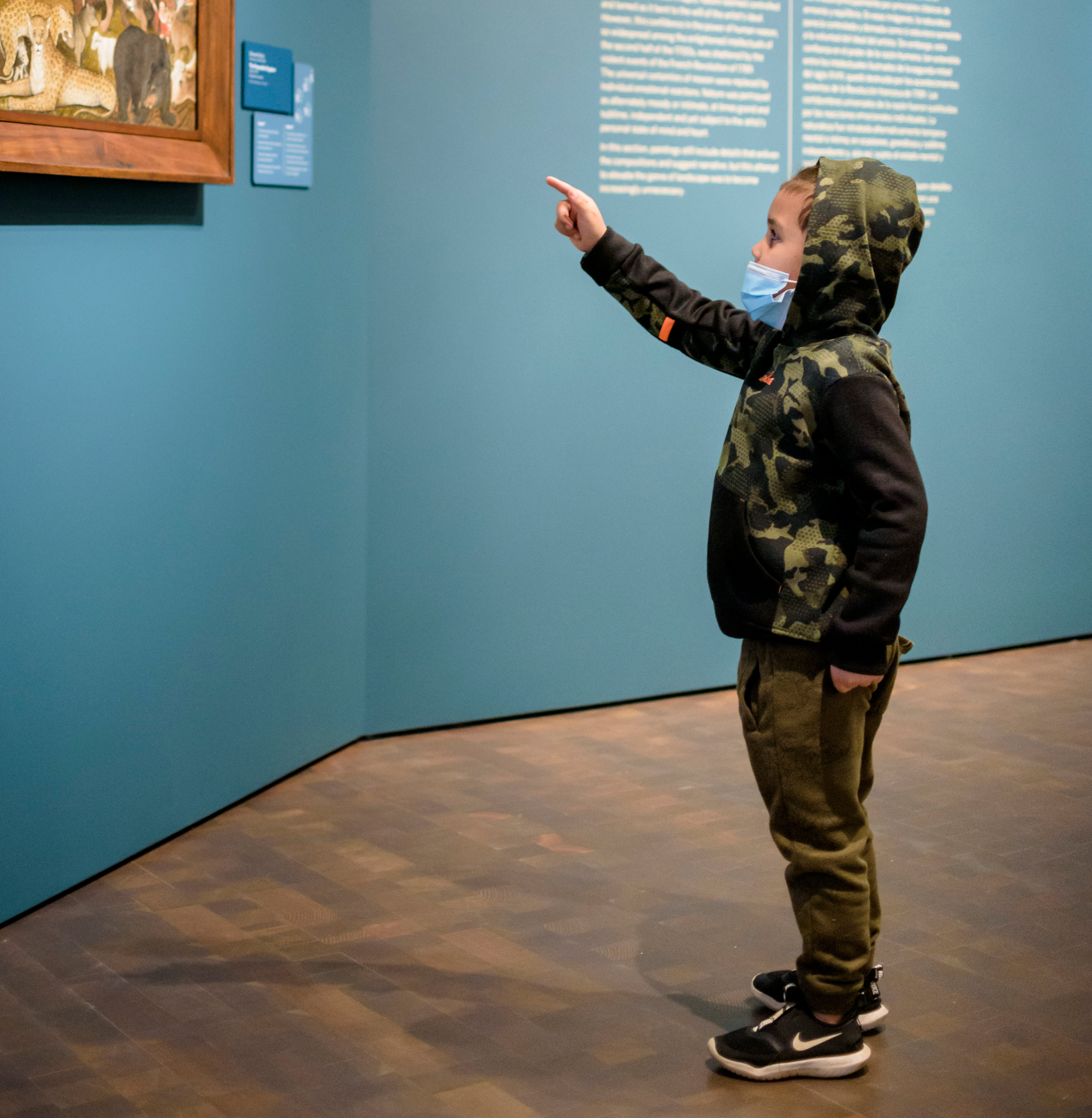 Young boy pointing at a painting