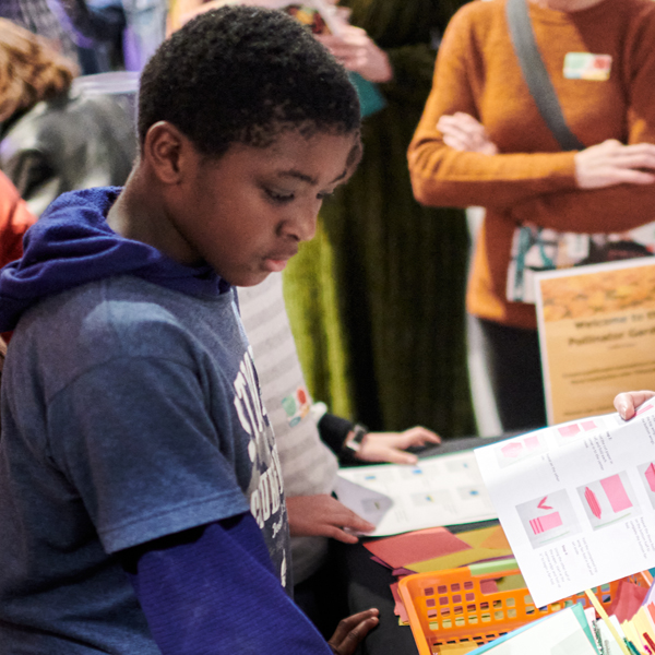 Kid looking at a table full of art supplies
