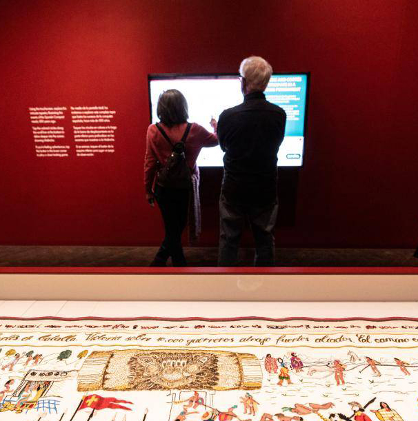 Couple interacting with digital screen inside the Malinche exhibition