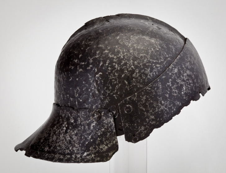 A helmet fitted close to the skull with a short attachment at the back angled outward to protect the neck.