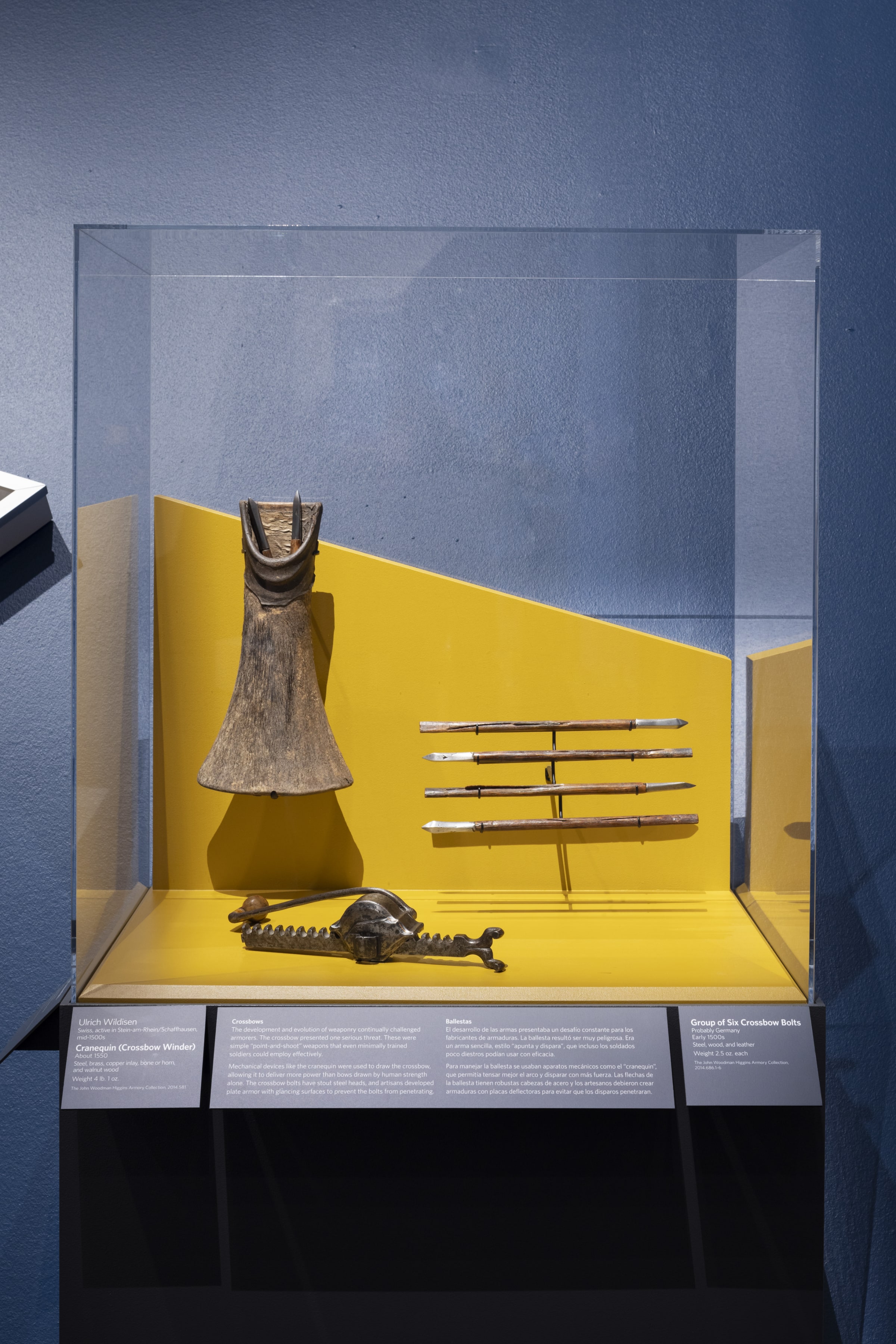 Medieval instruments for using a crossbow including multiple wooden steel-tipped arrows, a horn shaped leather quiver, and a long metal crank.