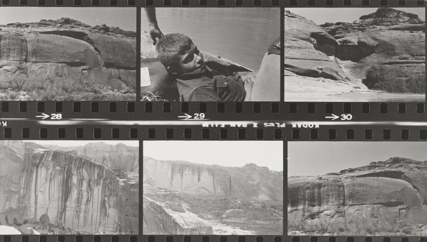 Two strips of black and white film negatives stacked on top of one another to make a two by three grid. The negatives feature various photos of the landscape.