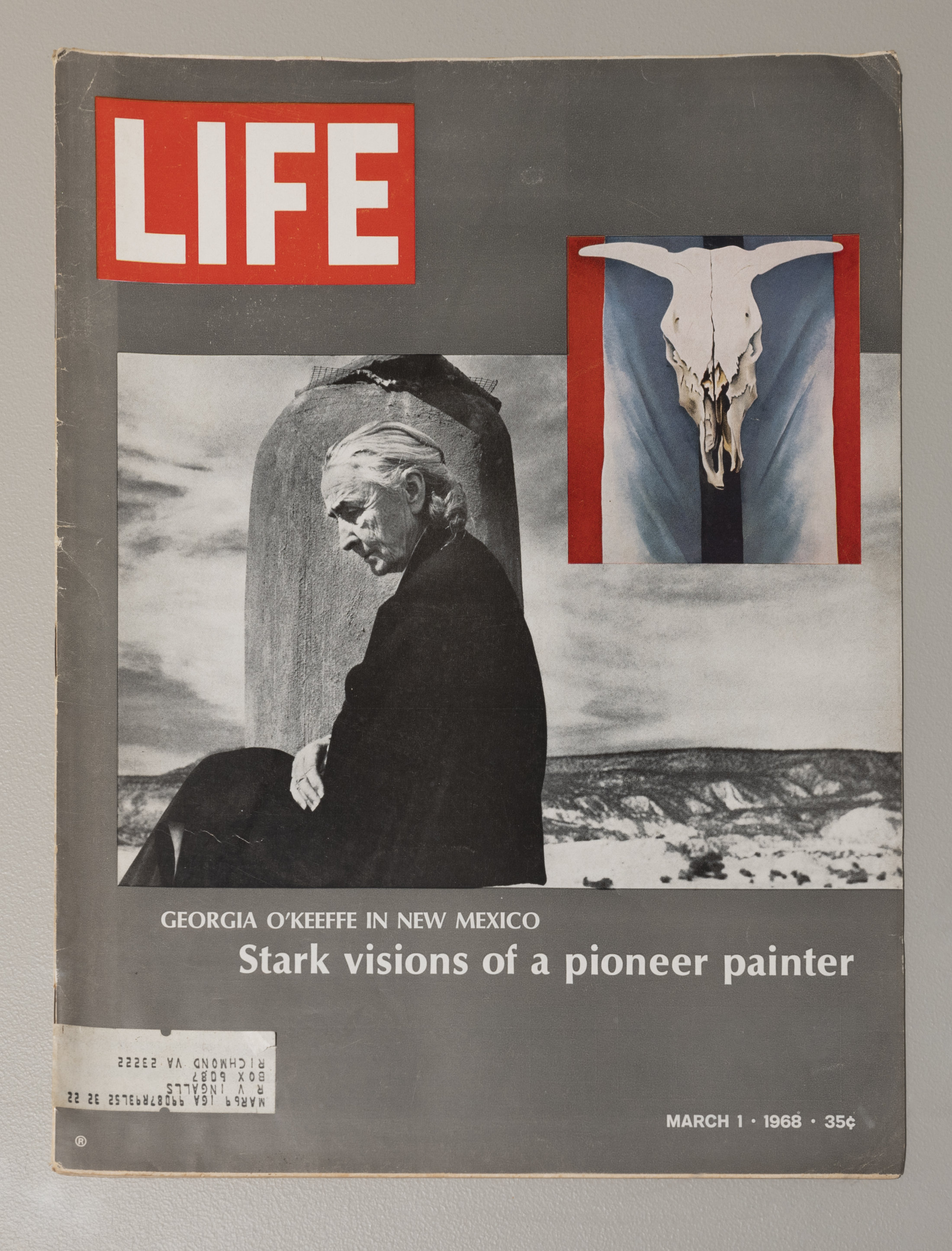 A cover of LIFE magazine with a portrait of O’Keeffe sitting profile and an image of a cow skull painting overlapping in the center. The words “Georgia O’Keeffe in New Mexico, Stark visions of a pioneer painter” are below the image of O’Keeffe.