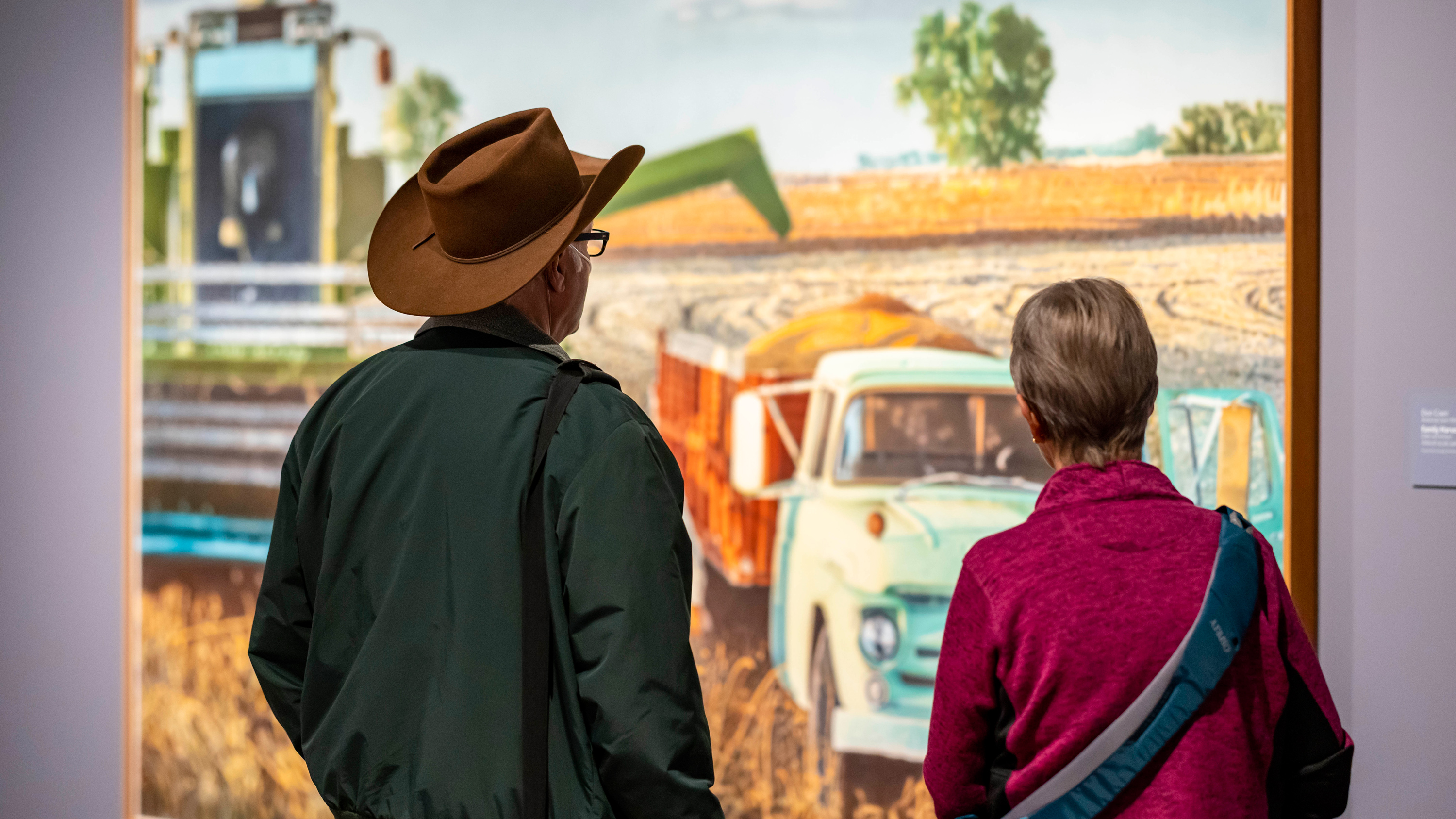 Elderly couple looking at a large colorful painting