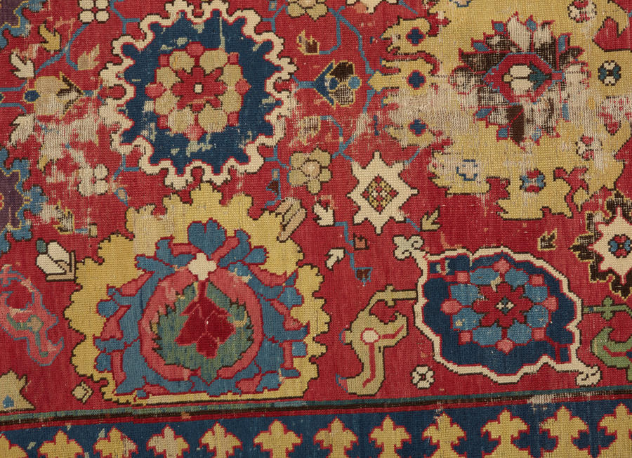 Detail of a red rug with circular shaped patterns