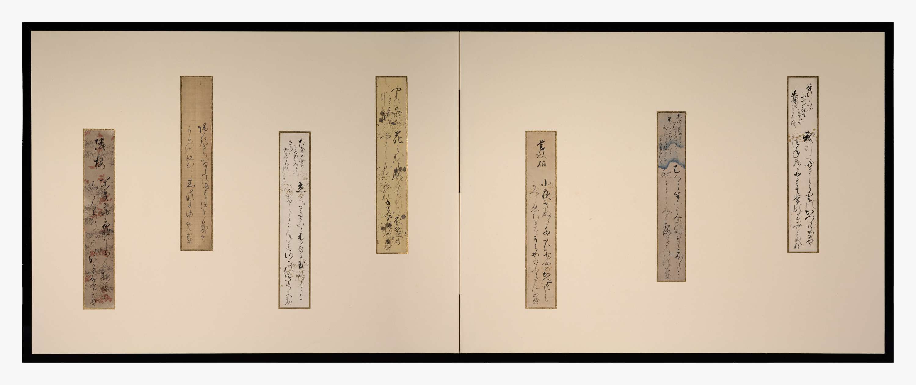 Seven decorated vertical paper slips with calligraphy mounted on a two-paneled folding screen at alternating heights.