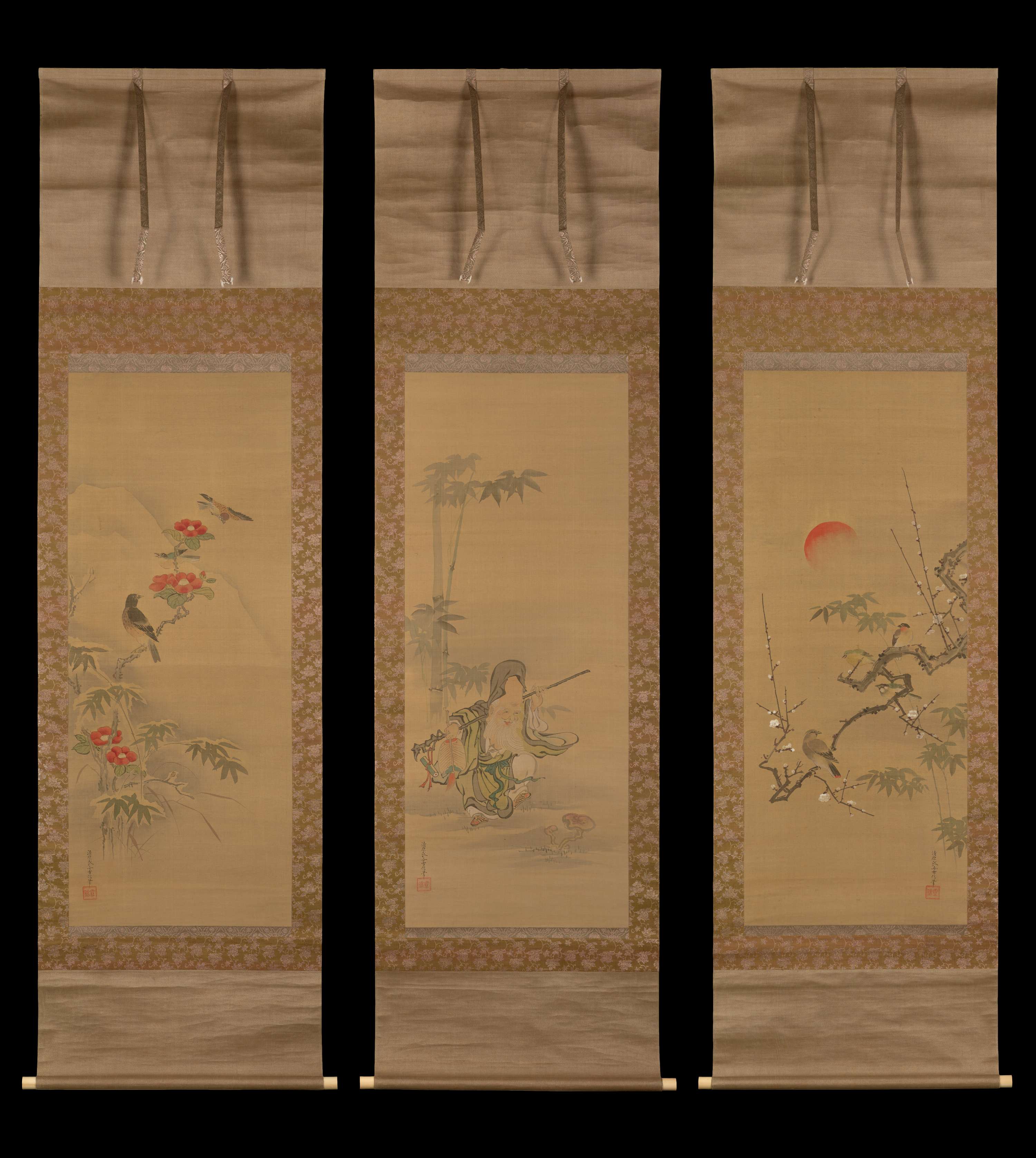 Three long, vertical hanging scrolls. In the center scroll, a man with an elongated head and a long, white beard carries a staff over his shoulders. In the left scroll, a gray thrush sits on a branch with red blossoms. In the right scroll, a red sun shrouded in mist hovers over birds sitting on a plum branch with white flowers.