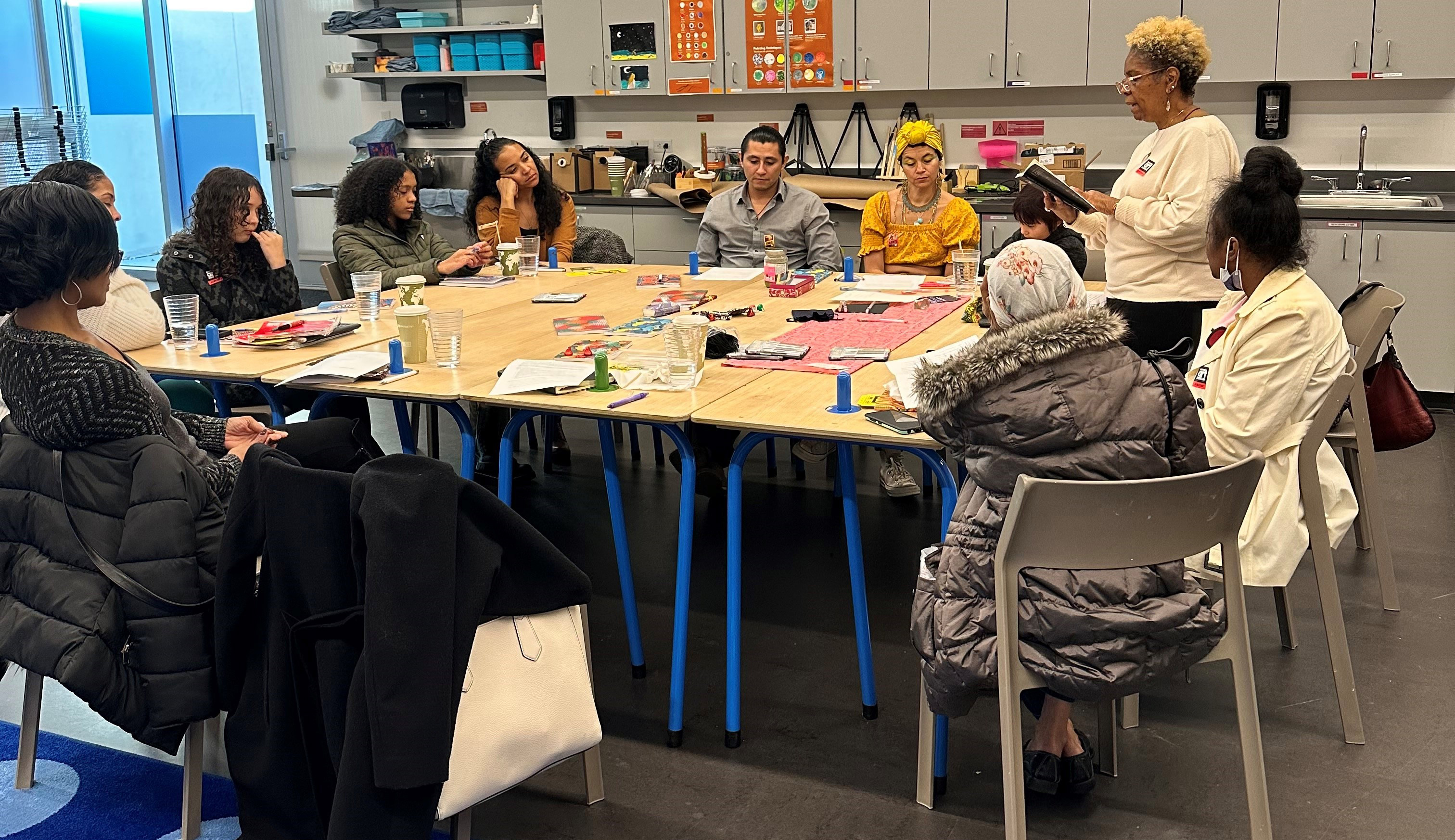 Group of students in a class gathered around a large table
