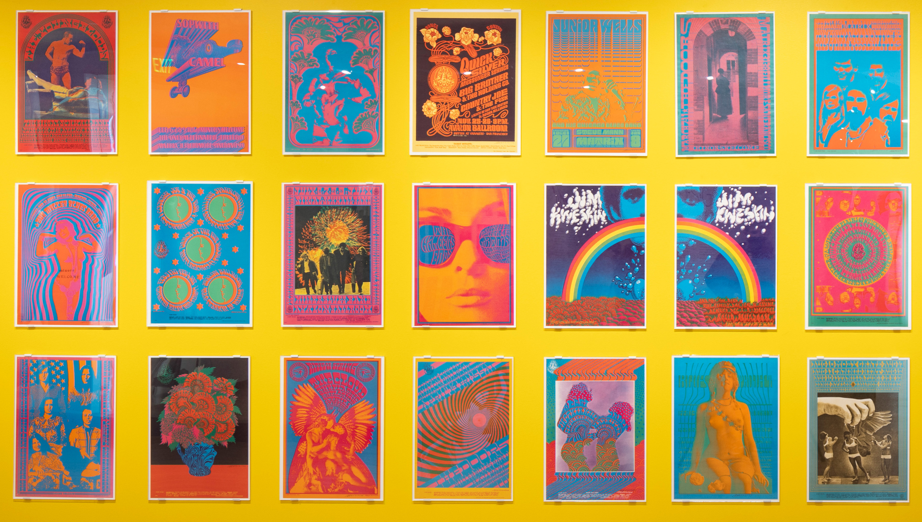psychedelic rock posters on a bright yellow wall in the design gallery