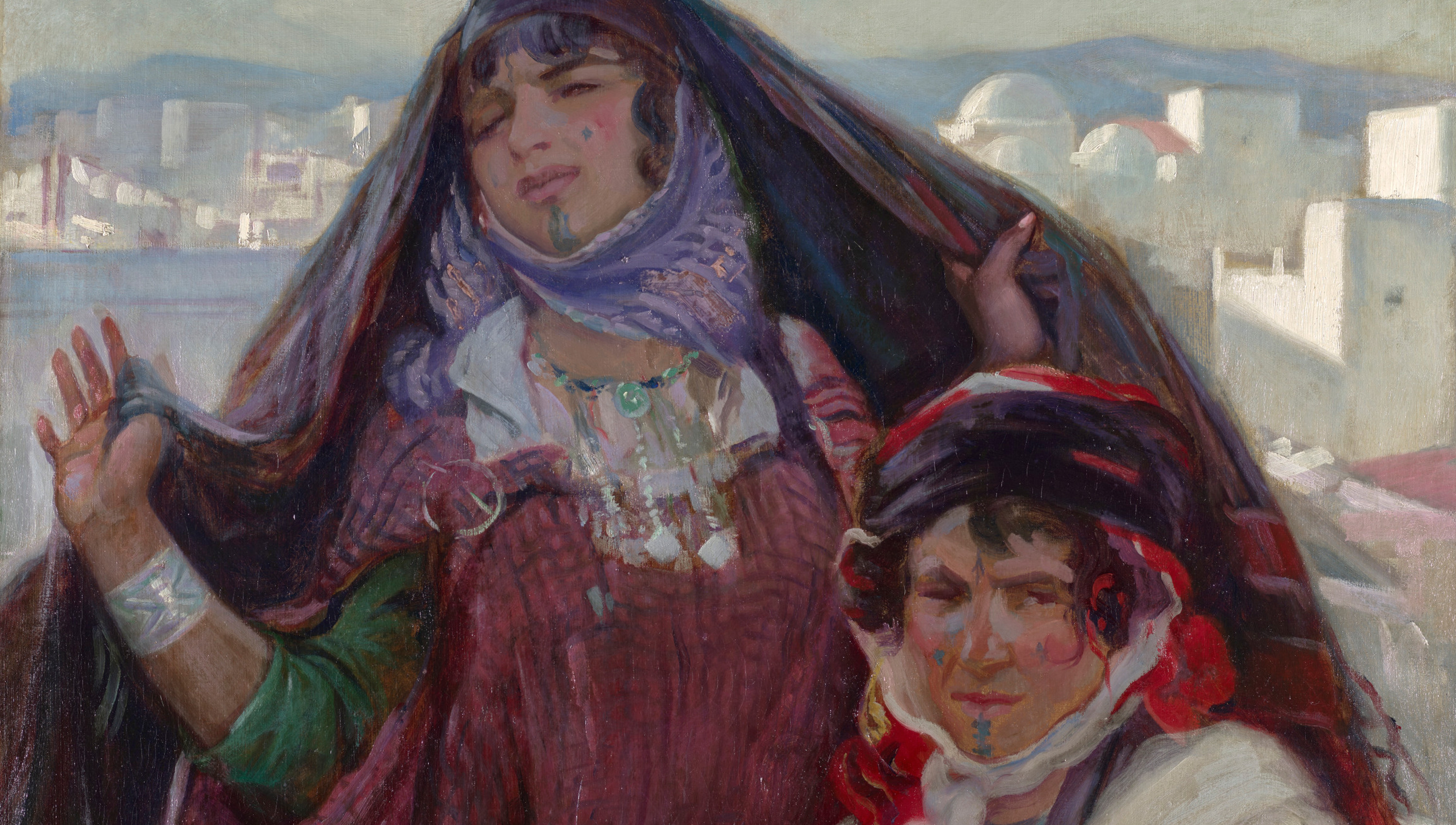 2 women on a rooftop with Tunisian skyline behind them