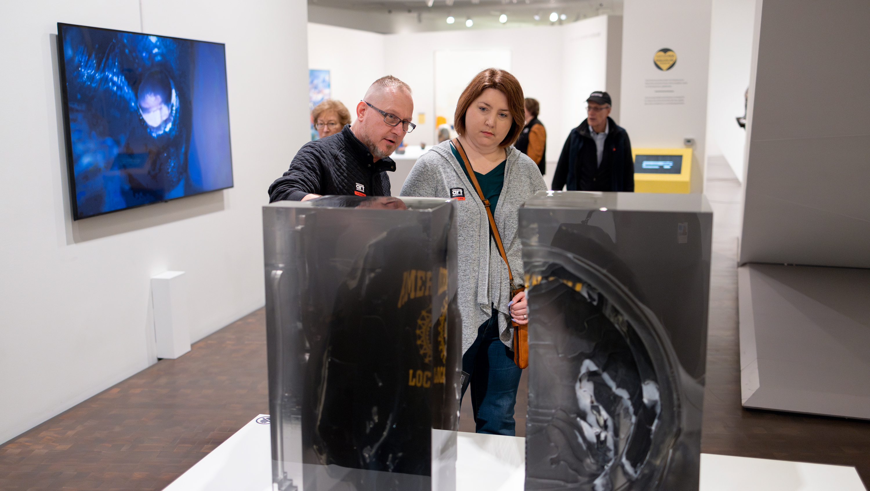 Male and female visitor examining two parallel sculptures