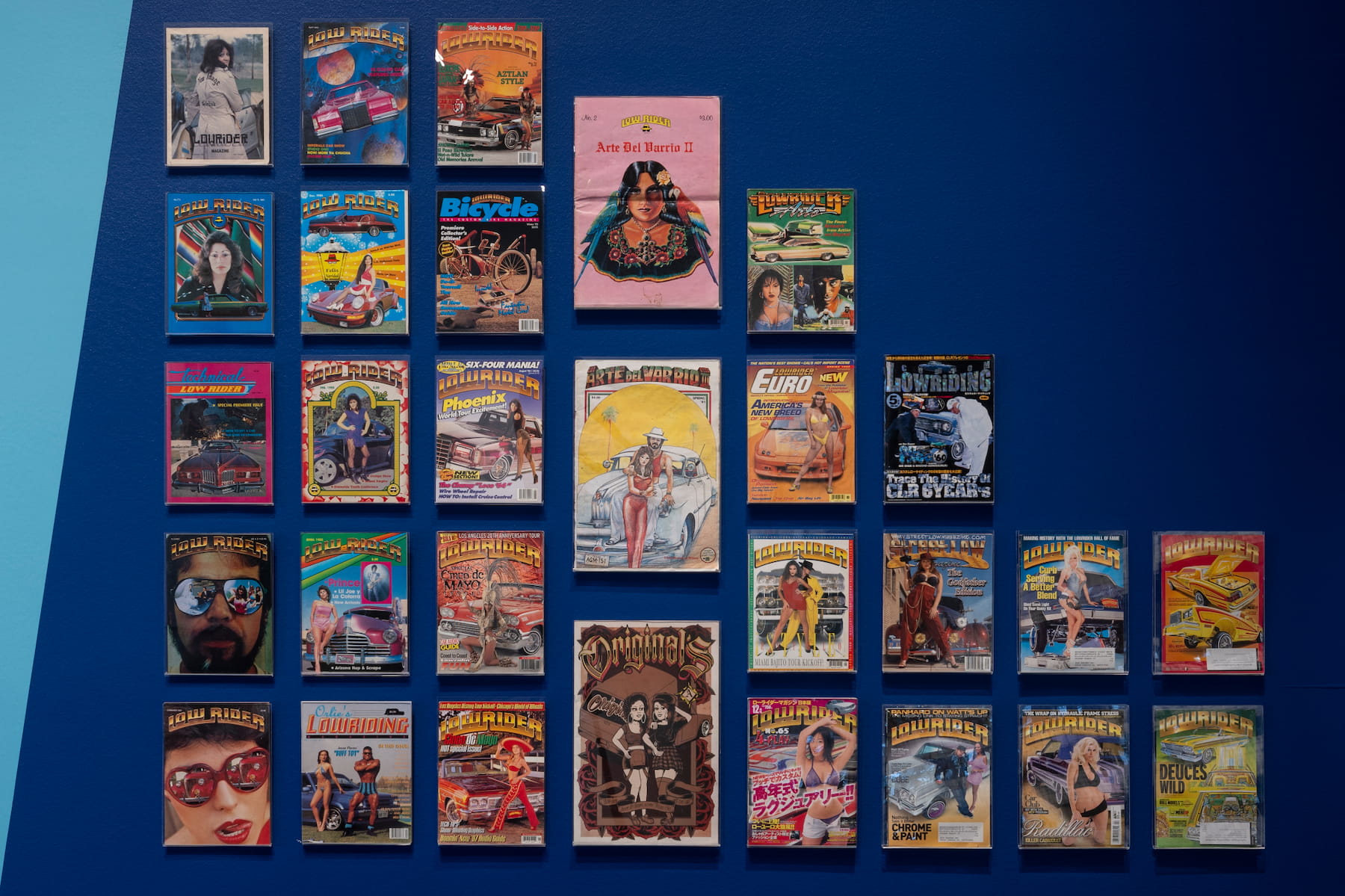 A dozen colorful magazines. Each magazine features an individual and a car through a photograph or graphic.