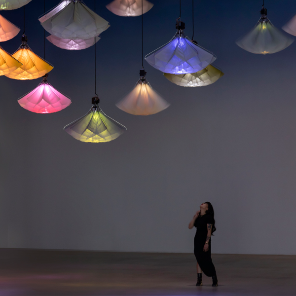 Woman looking up at hanging kinetic art light installations