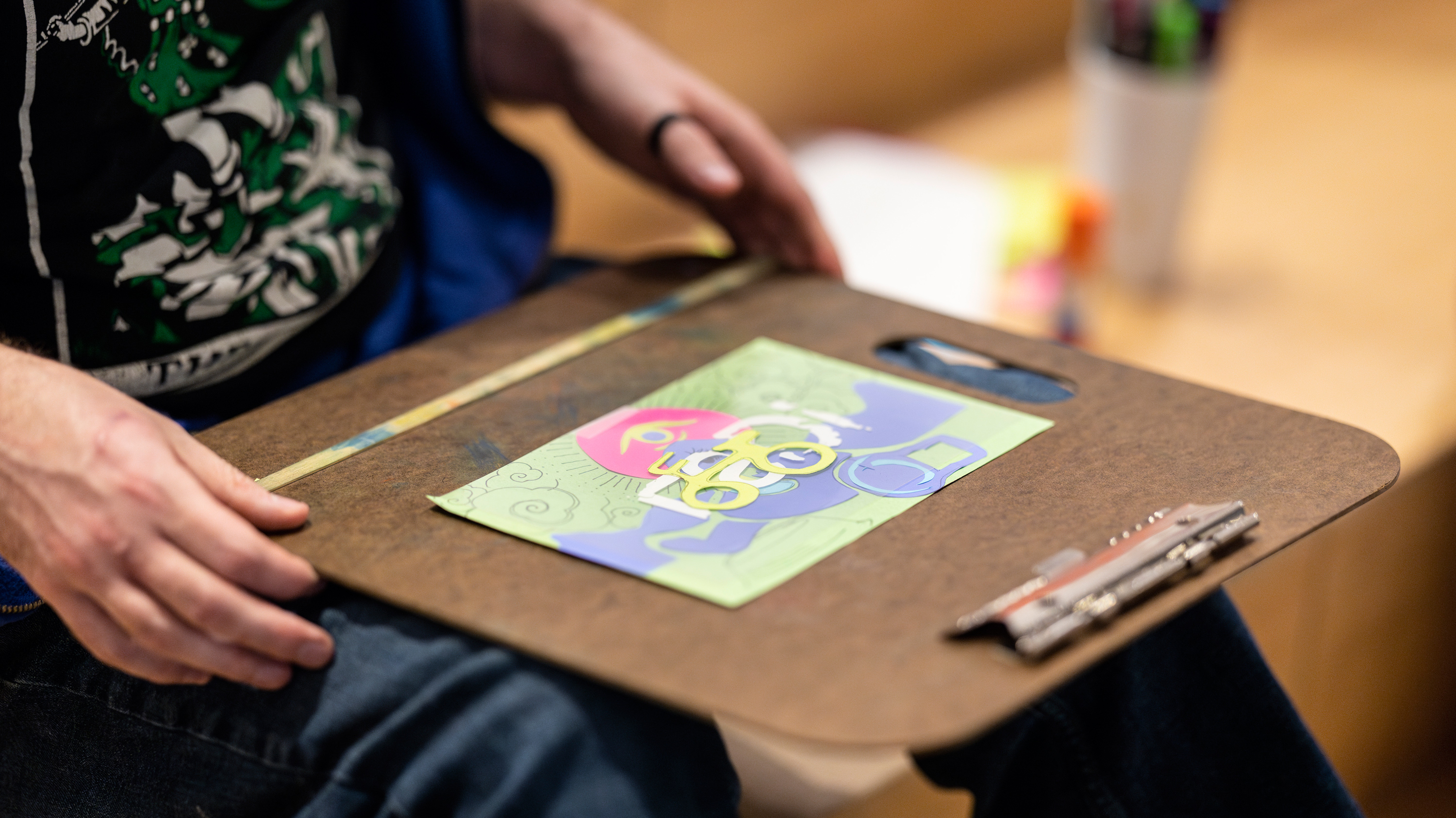 Close-up view of a person drawing on a clipboard