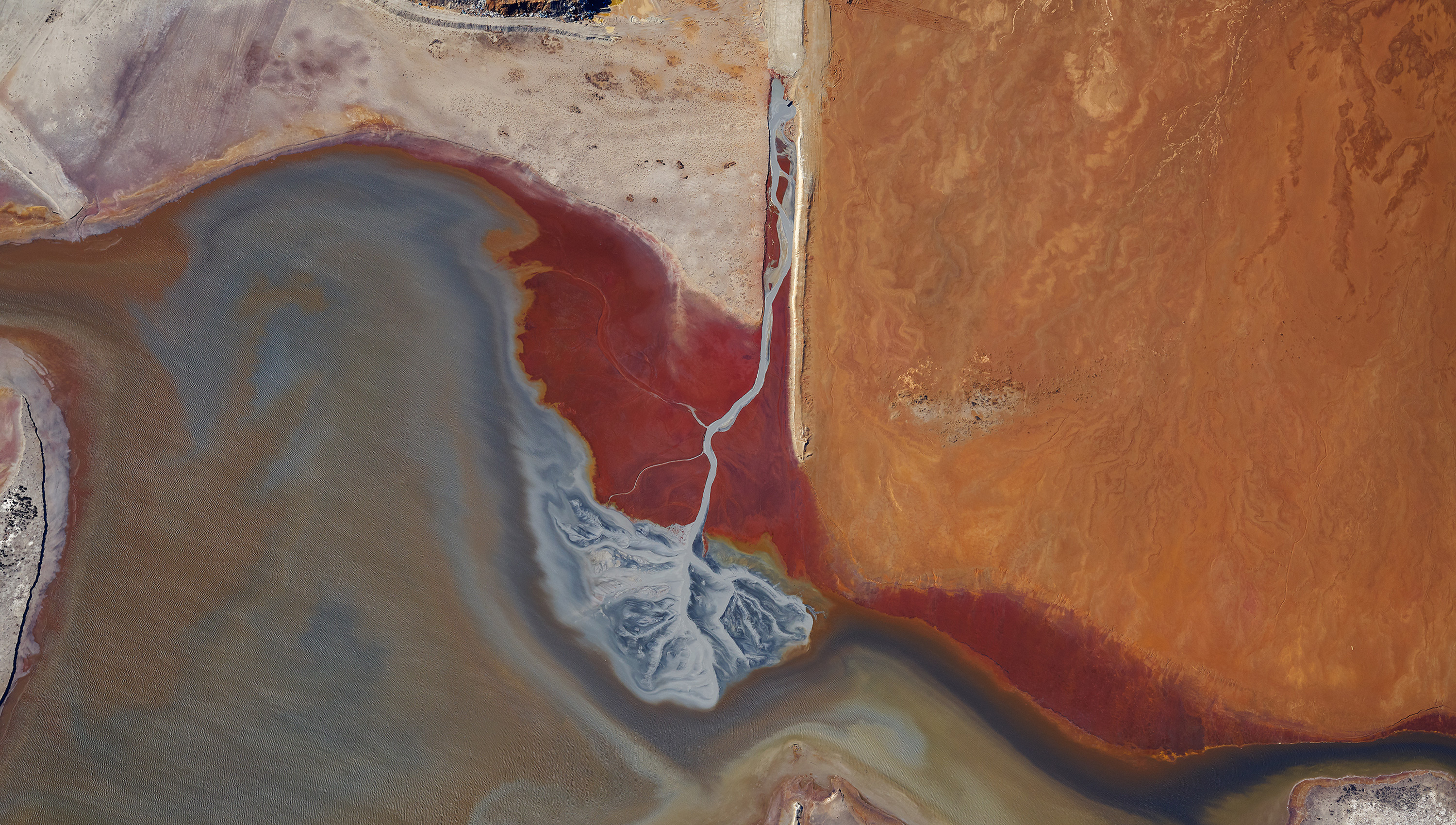 Overhead photograph of the great salt lake with rich red textures of sand