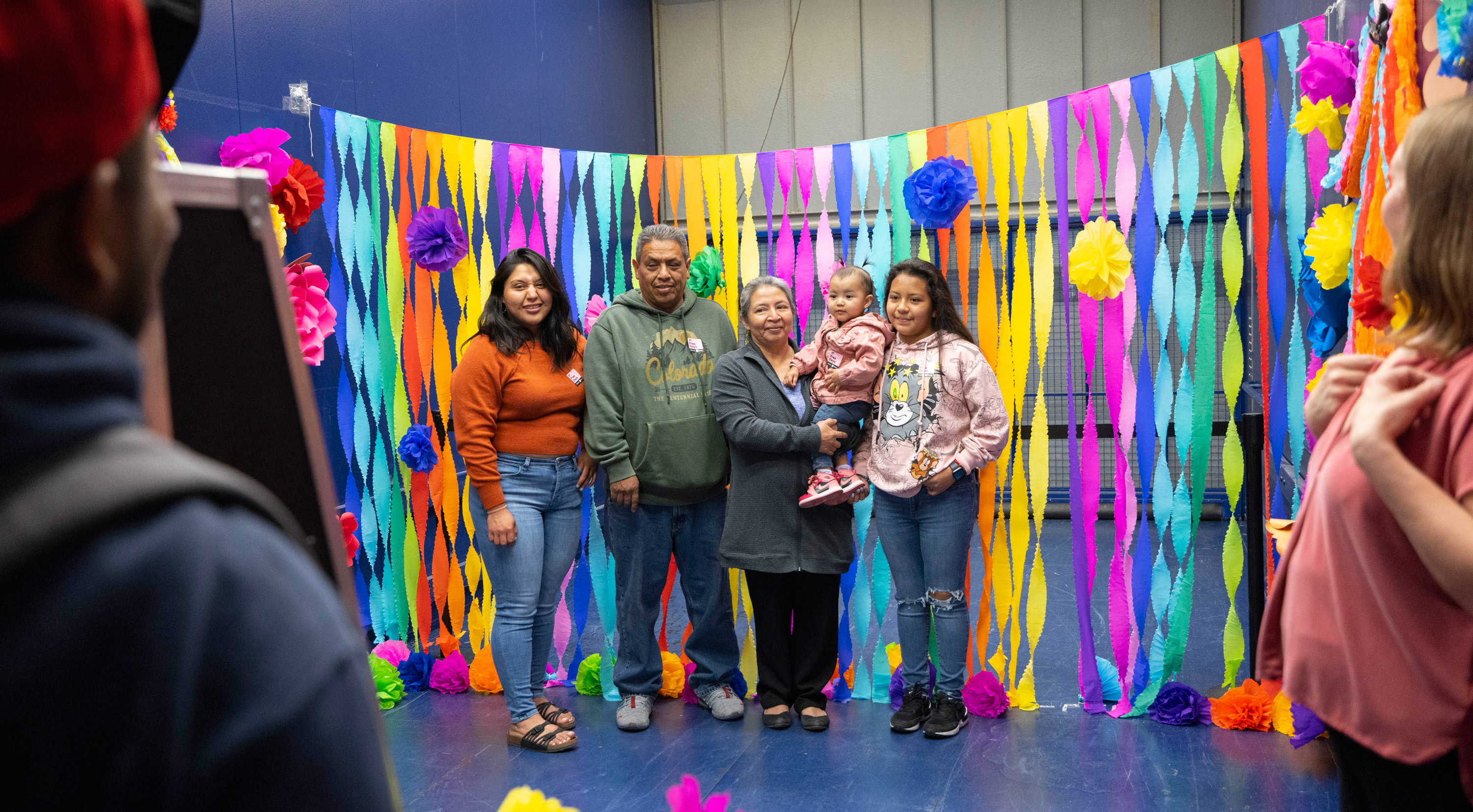 Family posing for a group photo in front of a row of colorful streamers