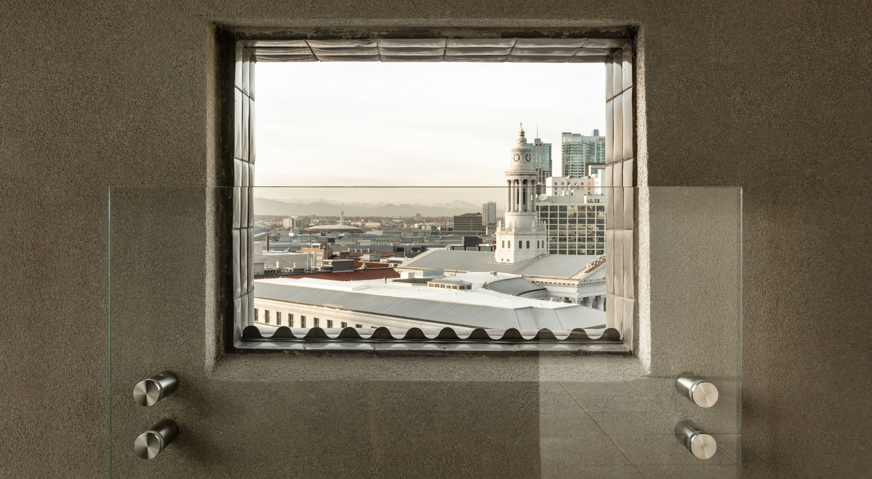 Photo looking out of a window in the Martin Building to the Denver city skyline