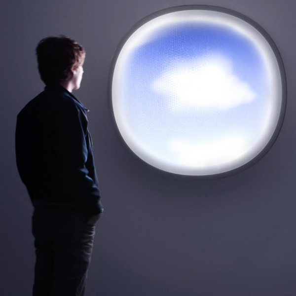 Man looking out a circular cloud-shaped window