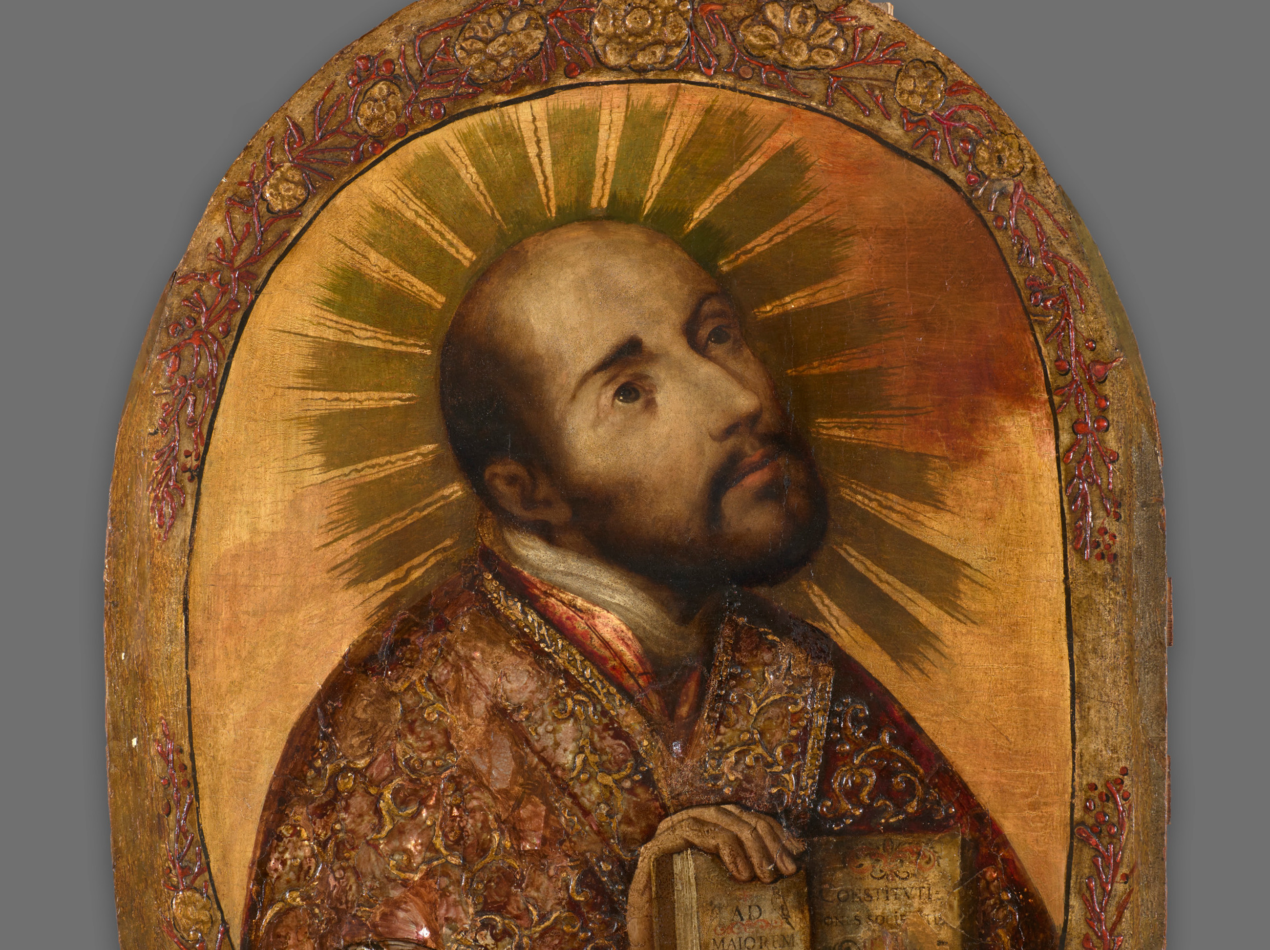Side profile of a golden Saint Ignatius Loyola glancing up