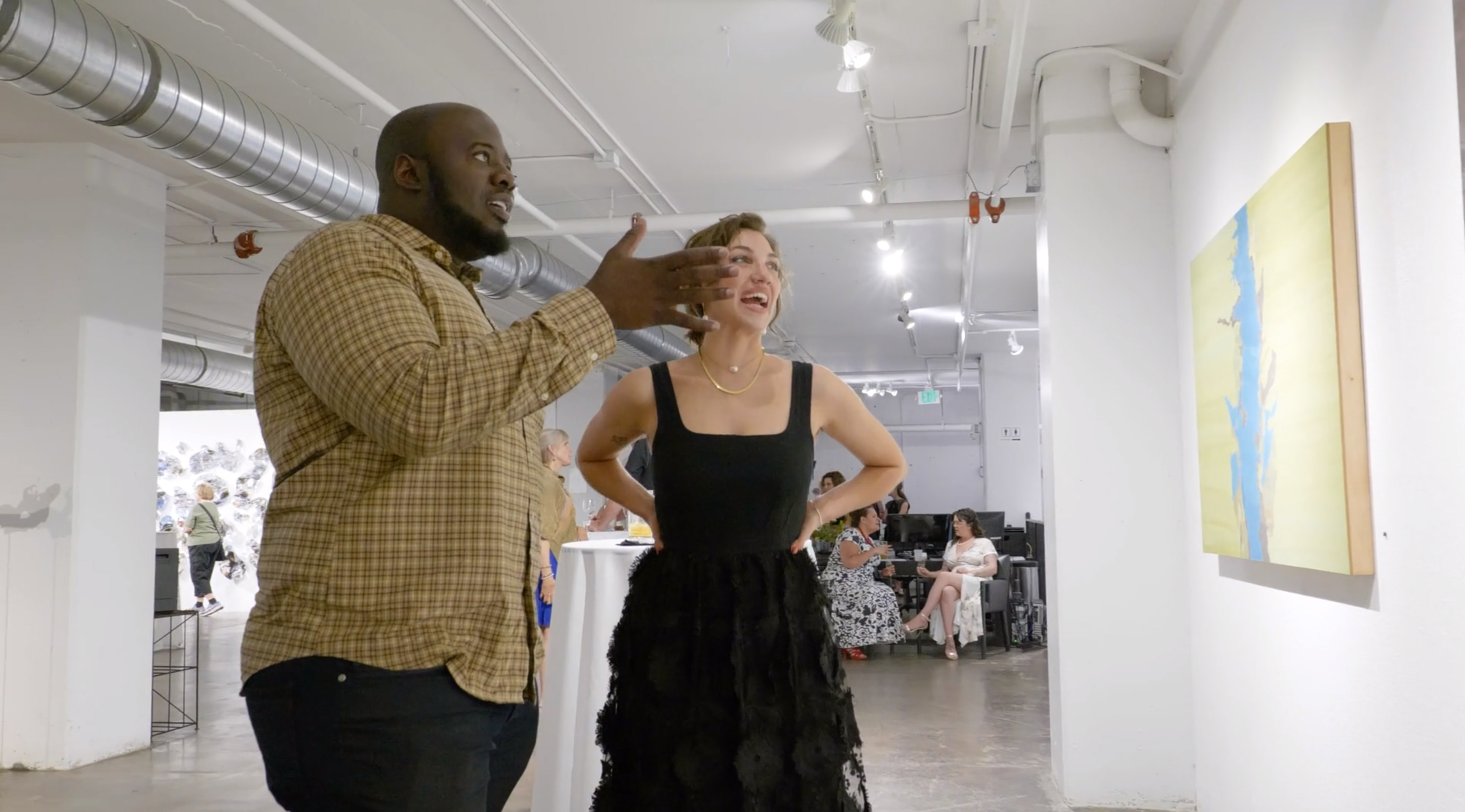 Two visitors discussing an artwork at the Walker Fine Art gallery