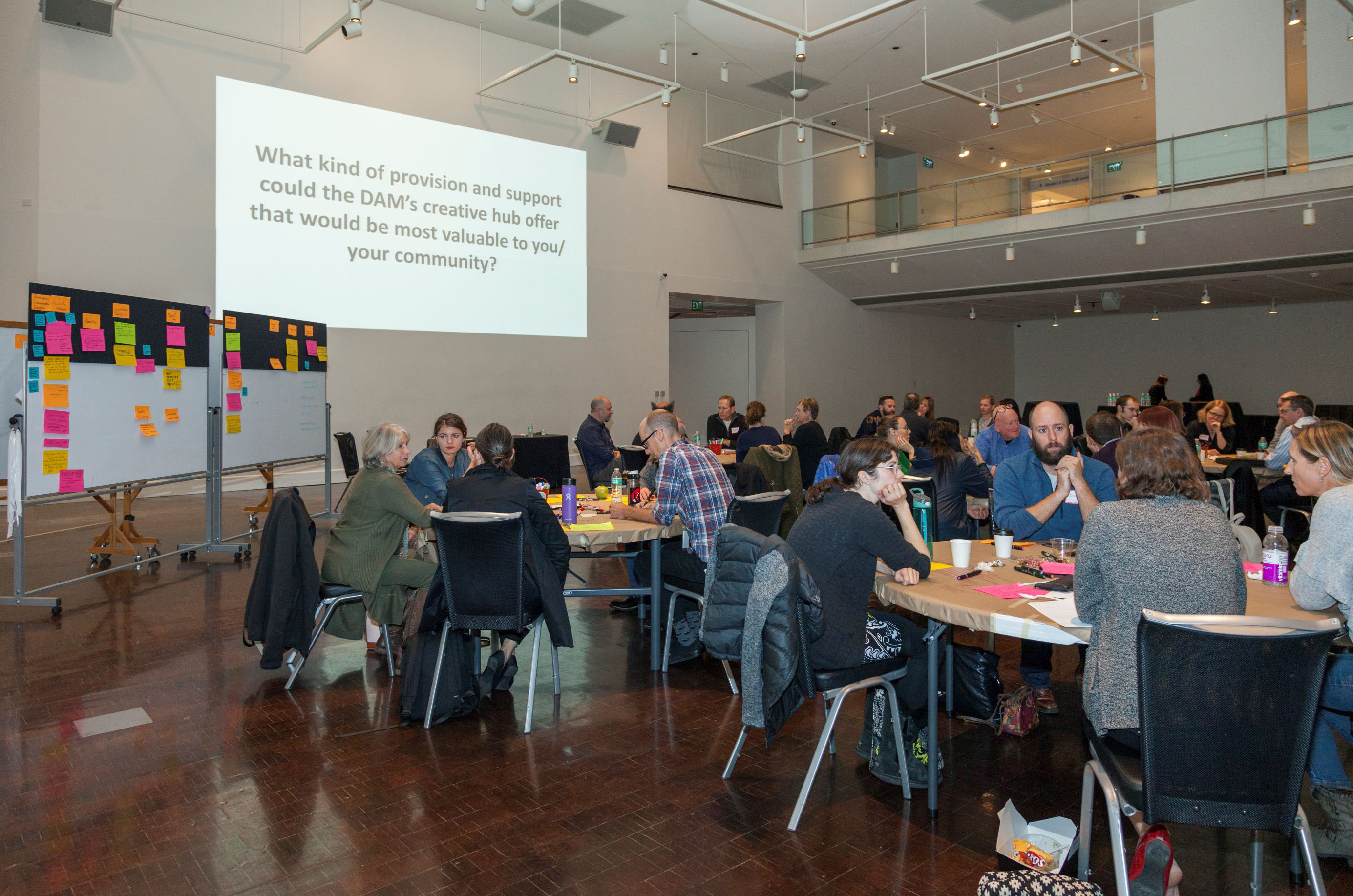 Conference room featuring circular tables of guests