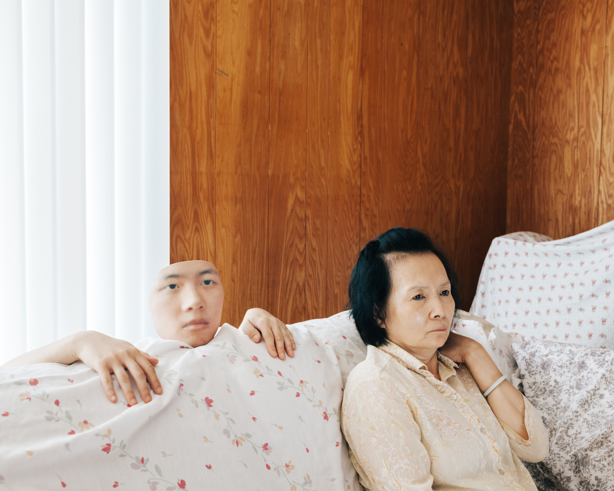 Artistic photo of a Korean man and his mother sitting on a couch