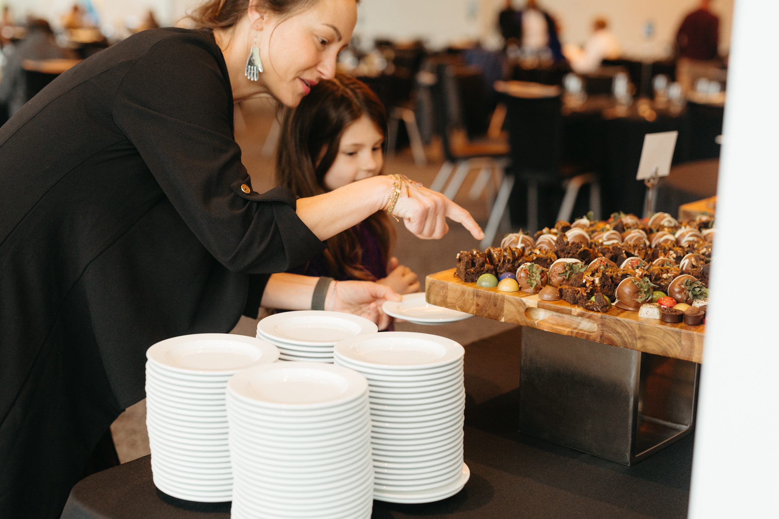 Mother and daughter looking at a tray of sweets at a buffet brunch