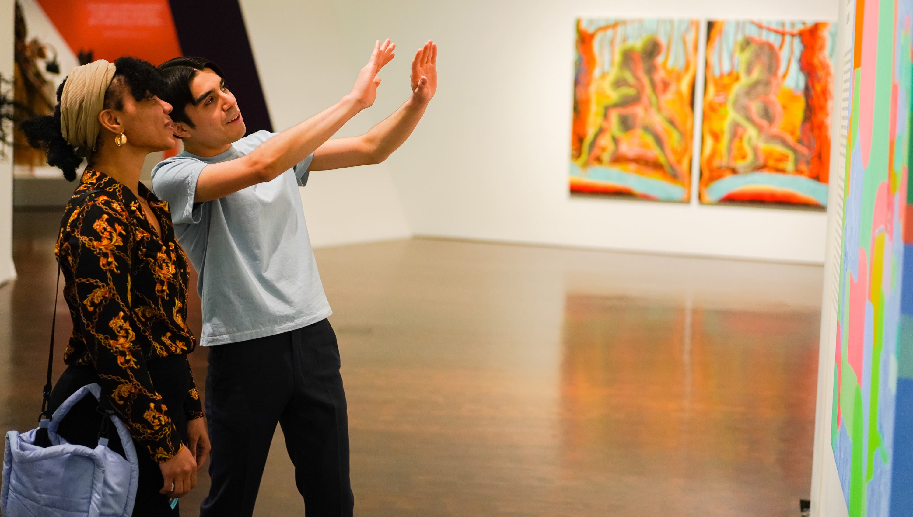 two people looking up at a painting in one of the galleries