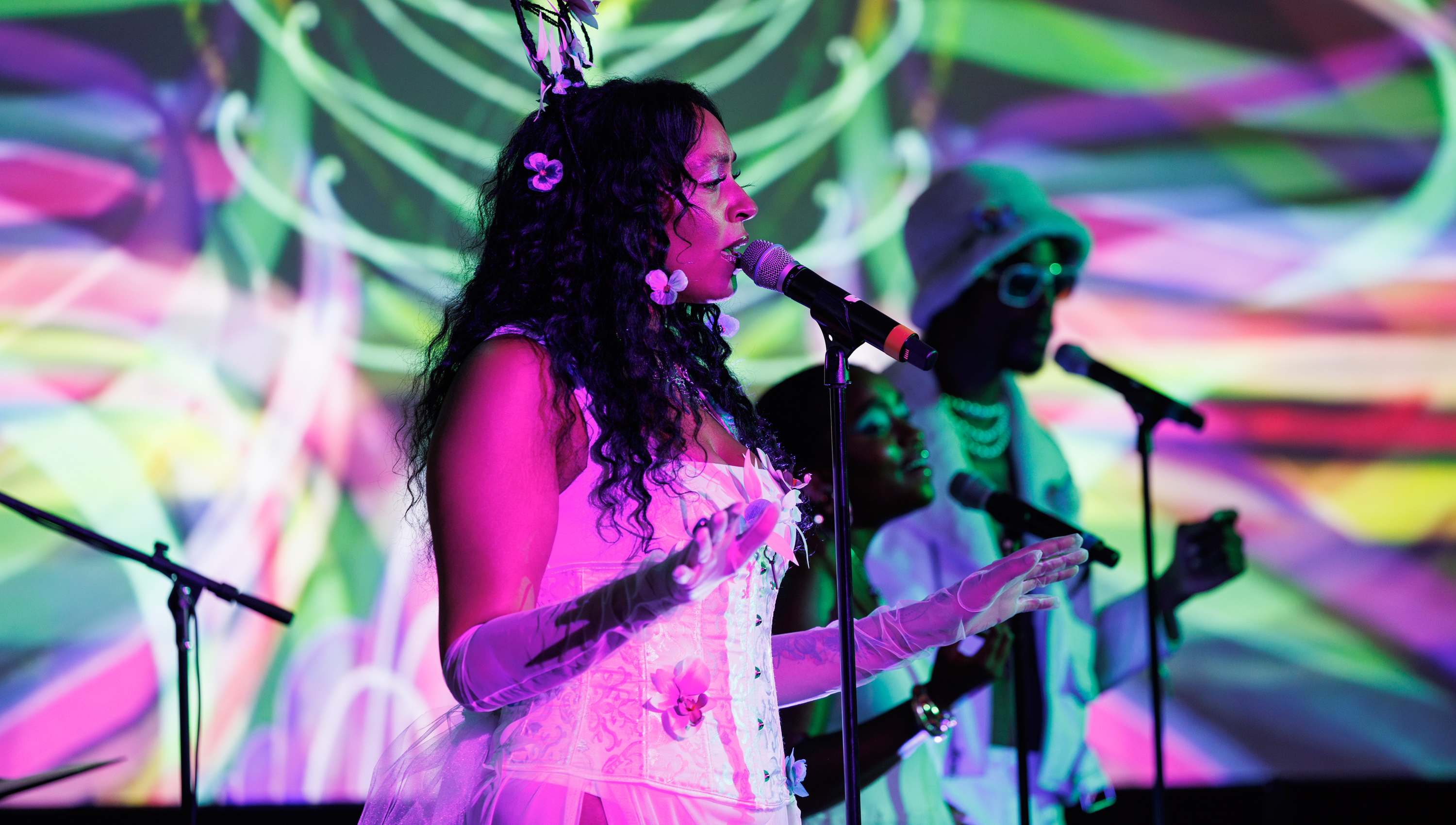 Woman and a man performing in front of a color synthesizer