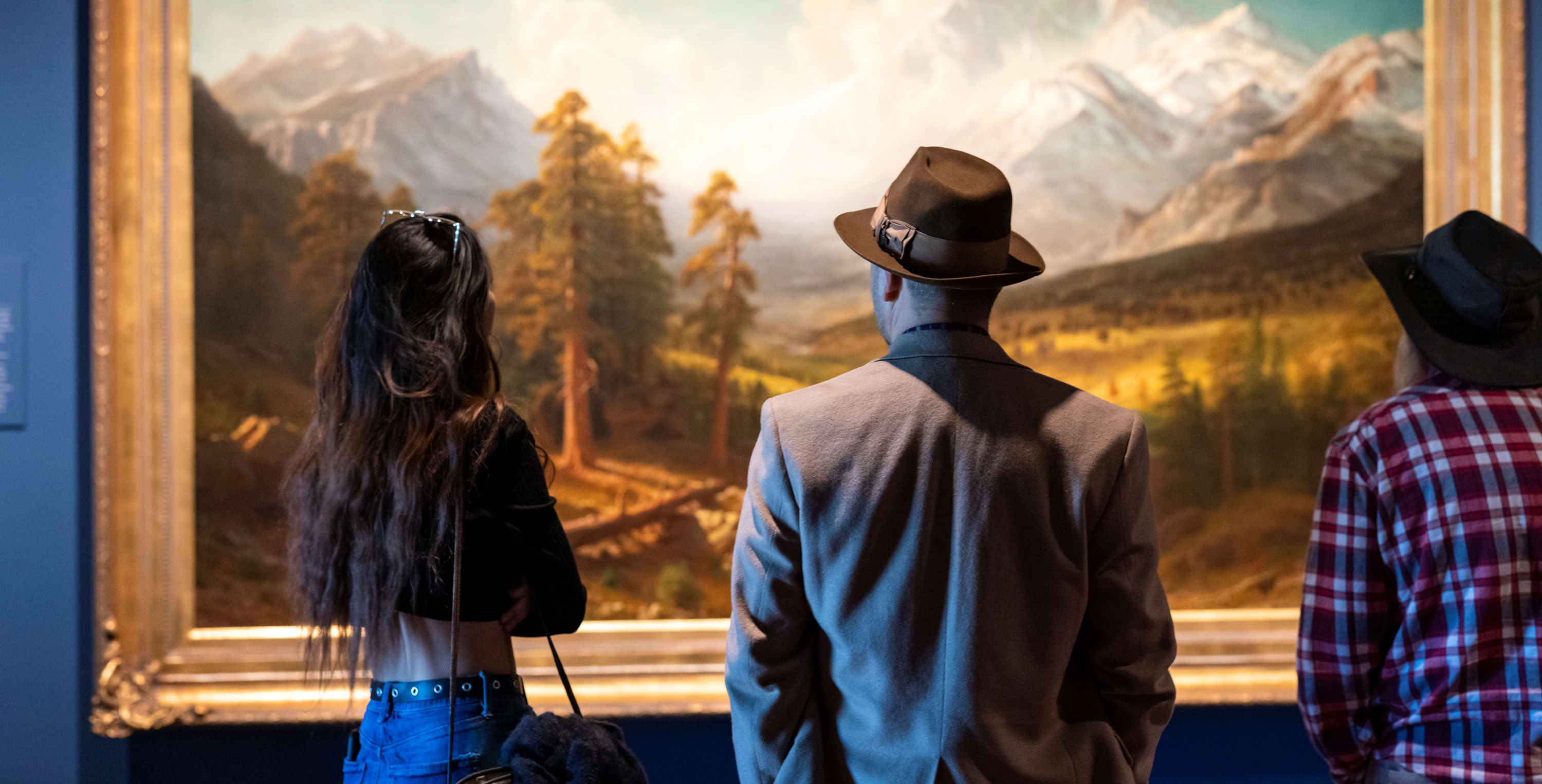 Three visitors looking at a large-scale painting