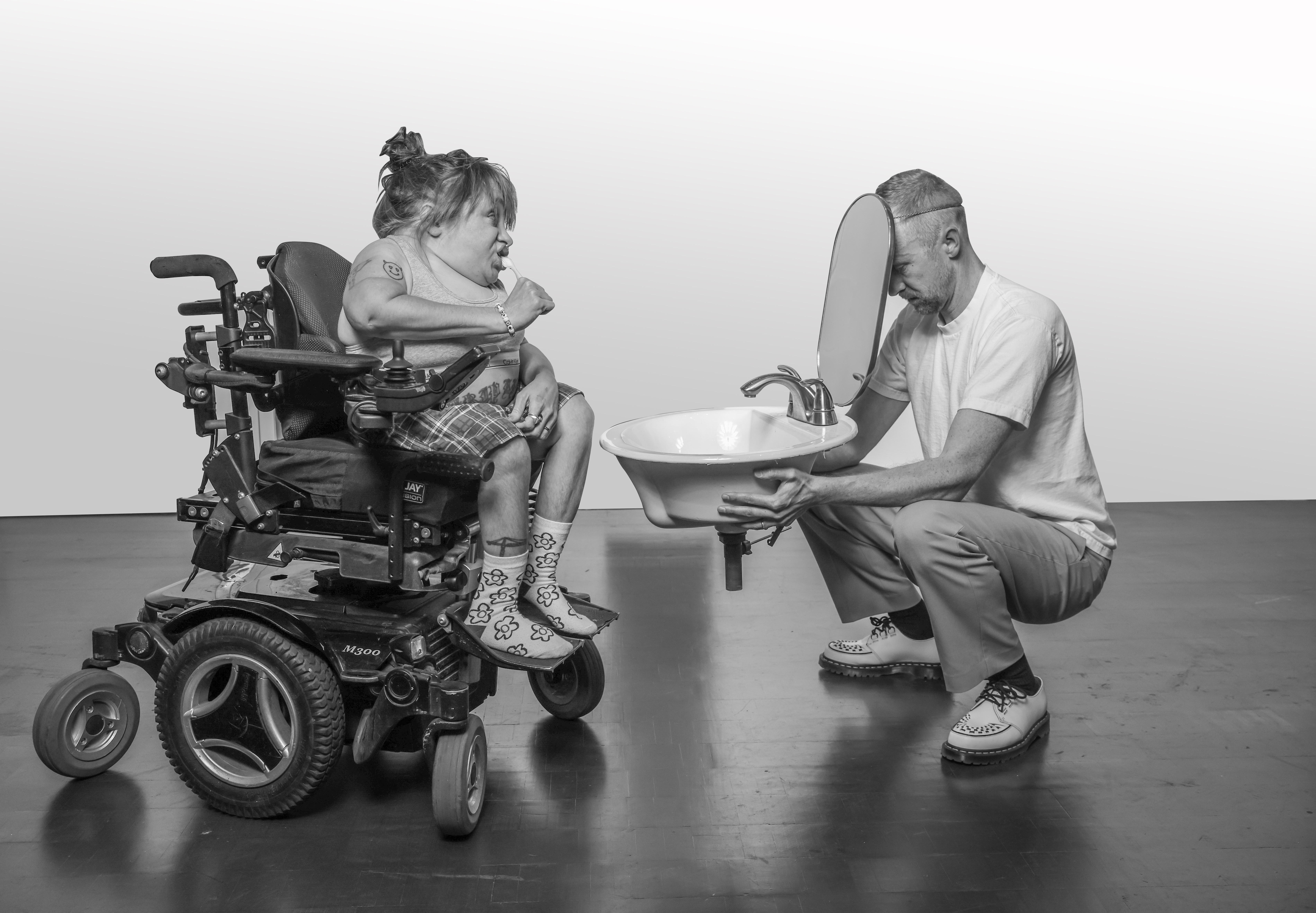 Black and white photo of a man and a woman in a wheelchair