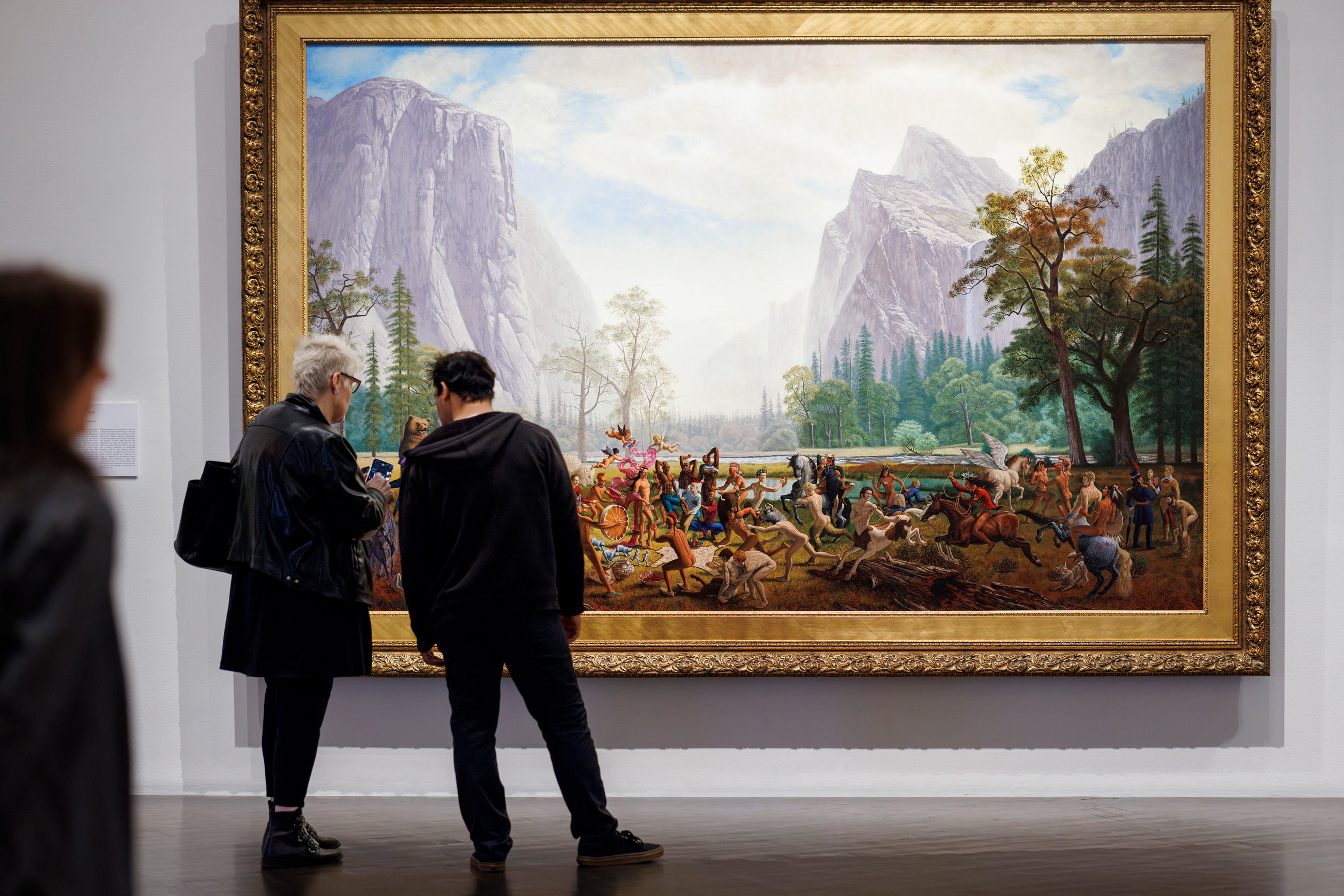people in front of a large painting in the exhibition