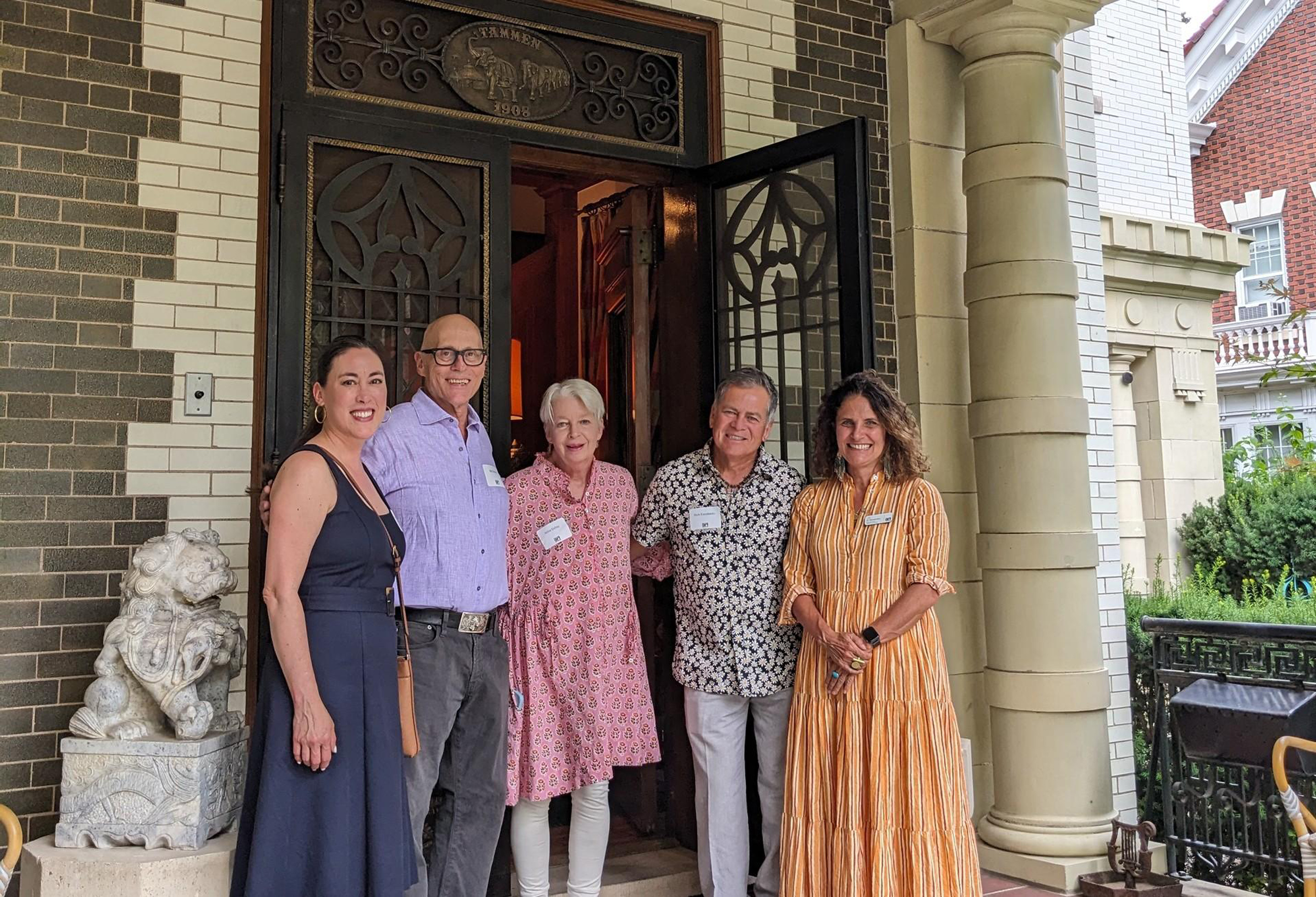 Group of older adults posing in front a home