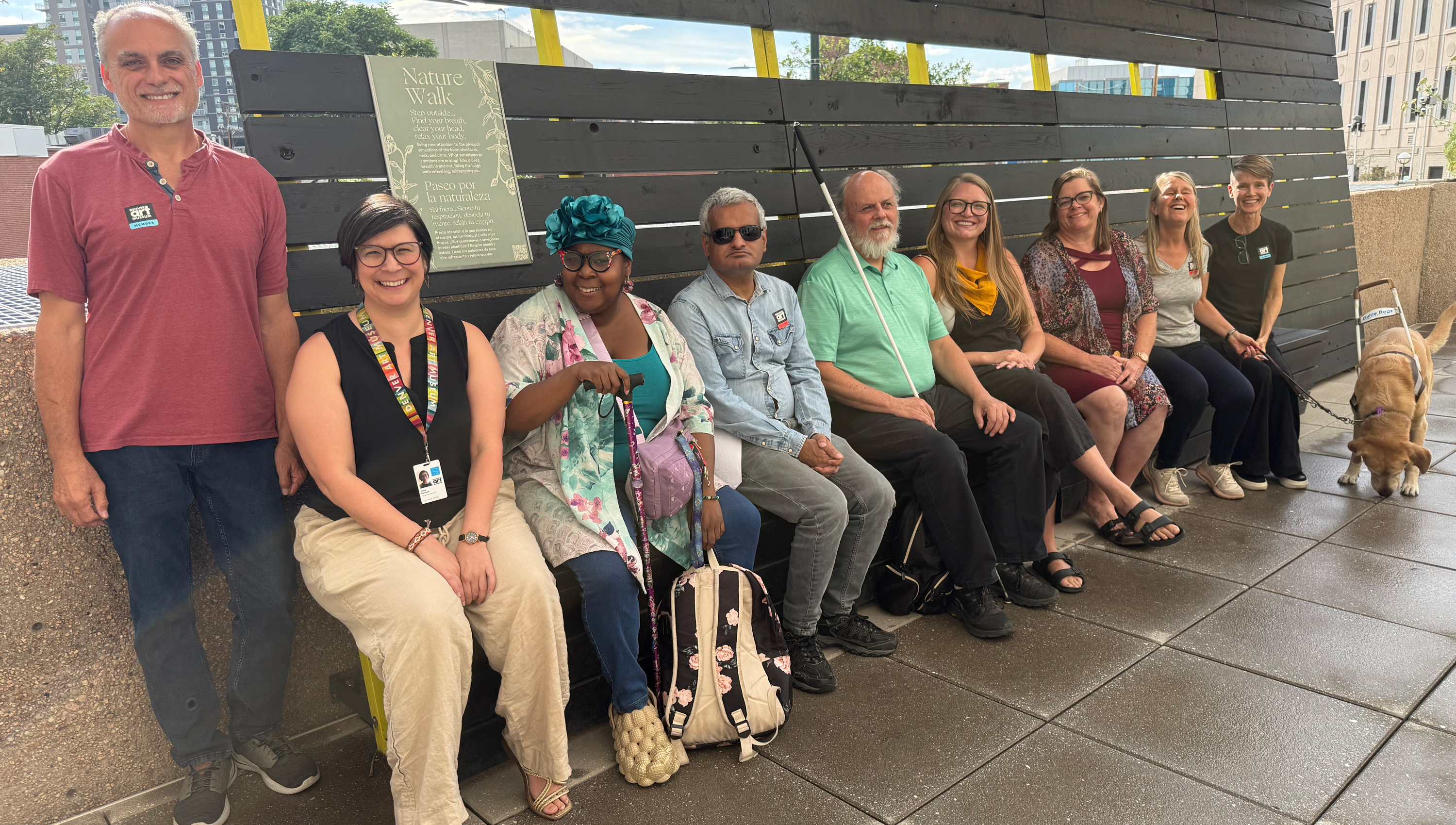a row of members of the access working group sitting on a bench in the DAM's sensory garden