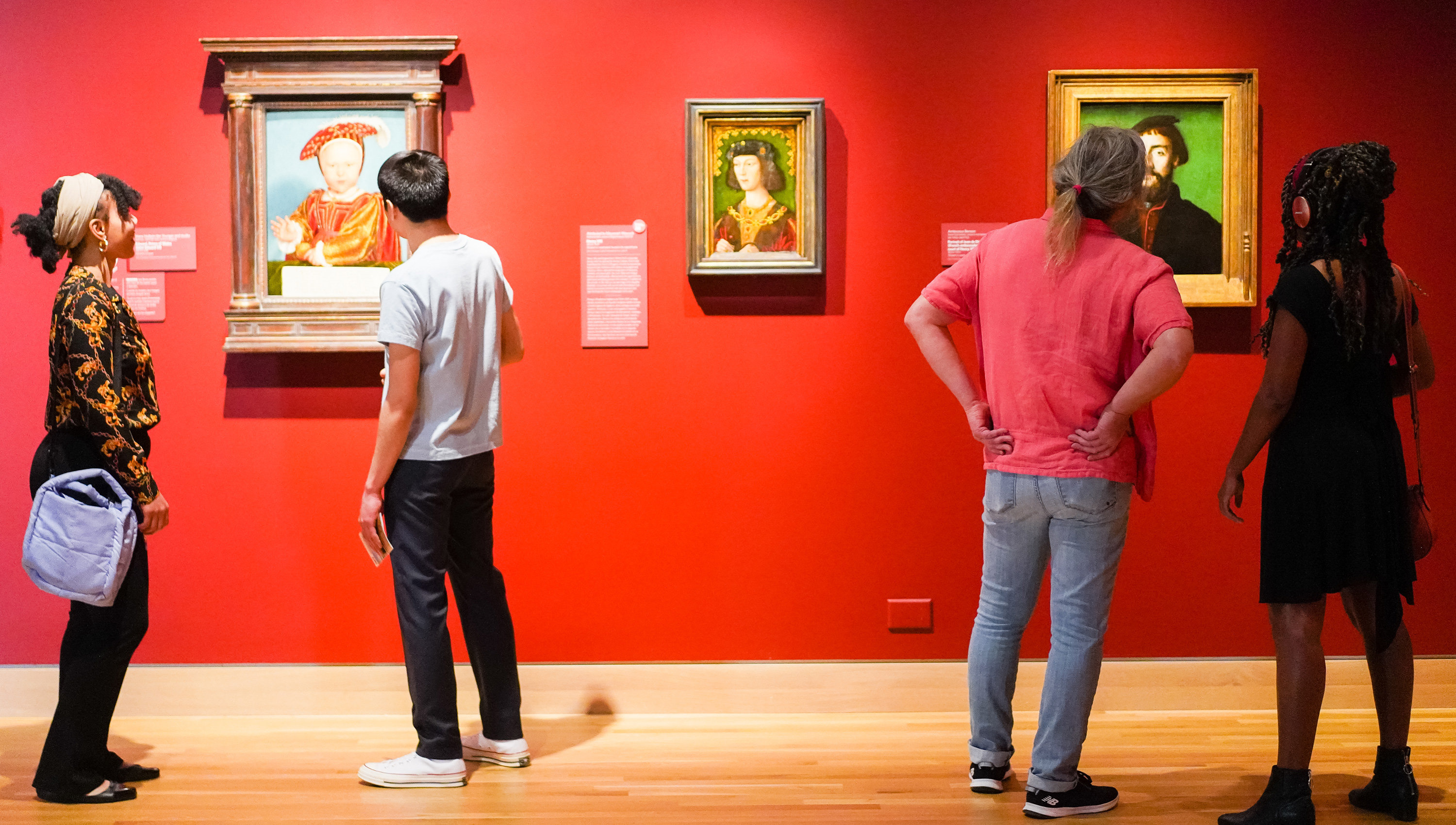 people looking at framed paintings in one of the Denver Art Museum galleries
