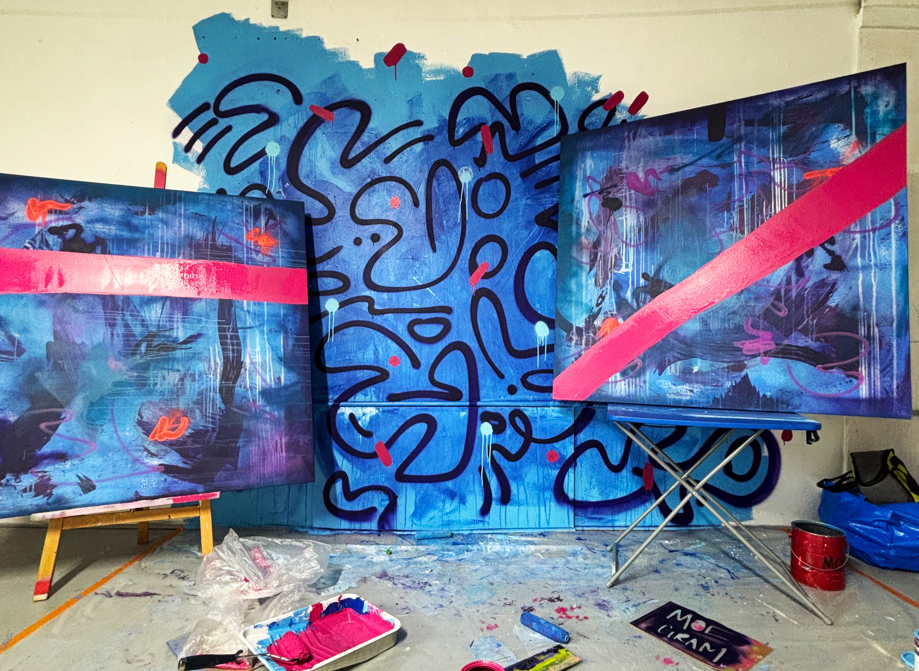 Interior of Moe Gram's art studio with blue abstract paintings abound