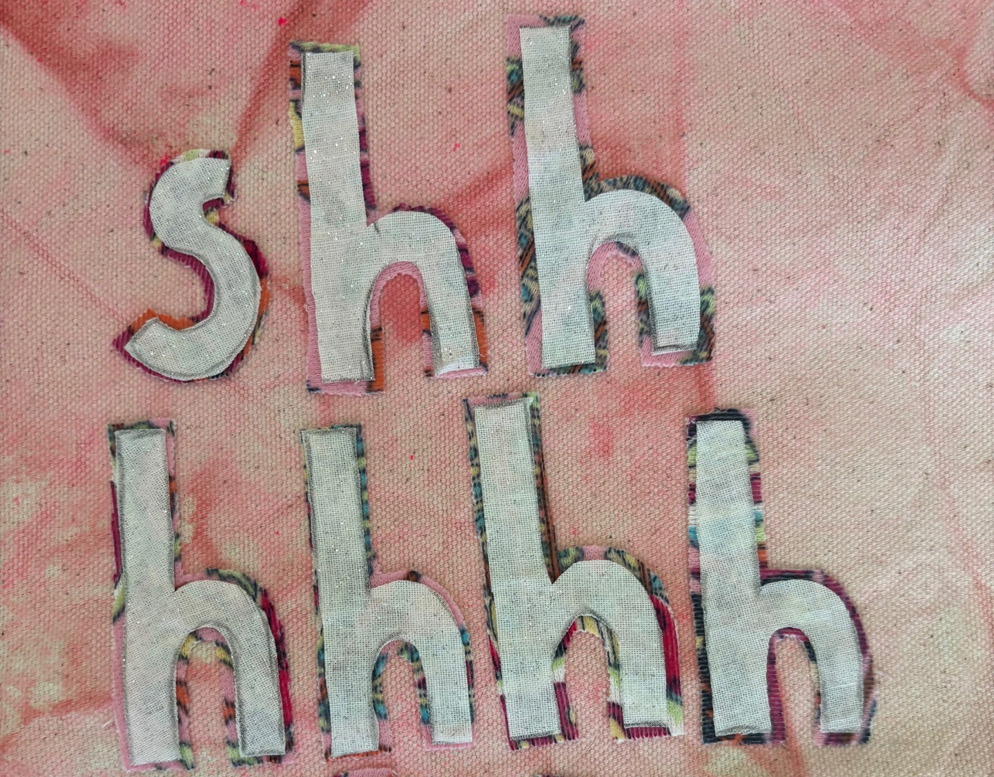 Tapestry fabric with the word "shhhh" embroidered on it