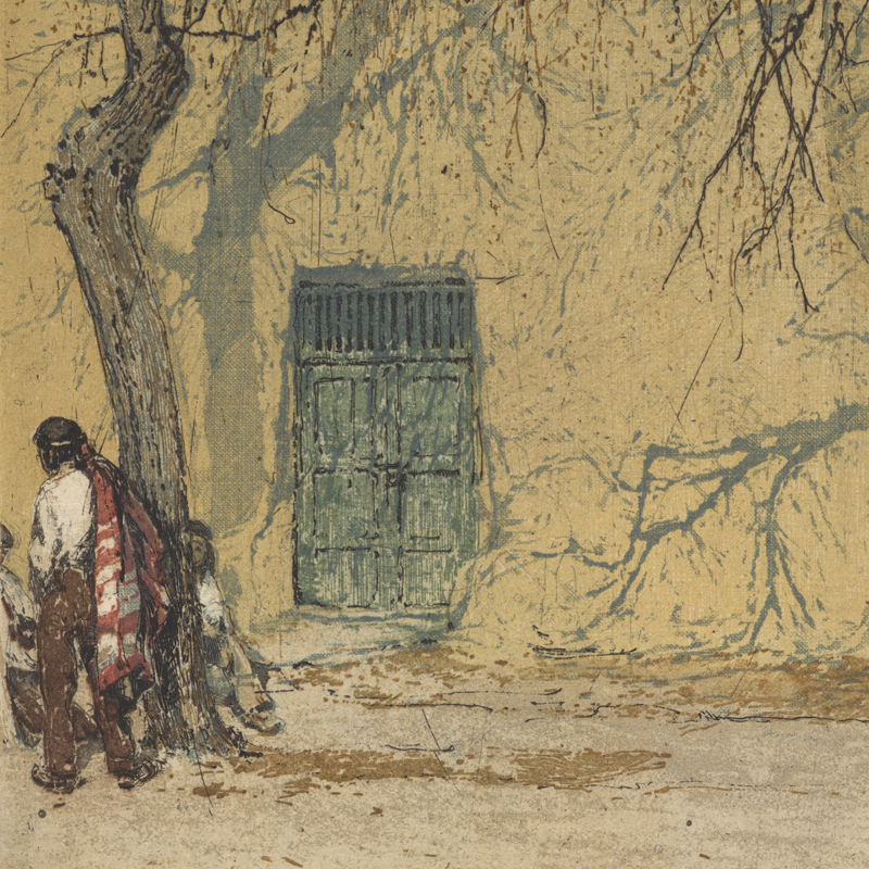 Man walking past a pueblo-style building and tree in Sante Fe, New Mexico