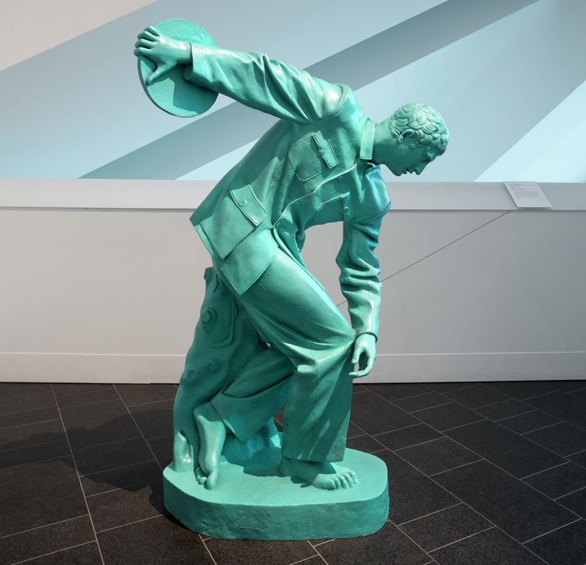 Blue statue made out of bronze in an active crouching position