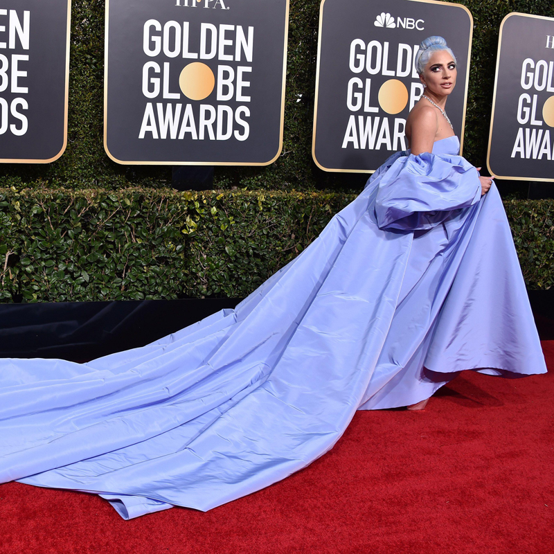 Lady Gaga in a long, flowing light blue dress attending the red carpet for the Golden Globe awards
