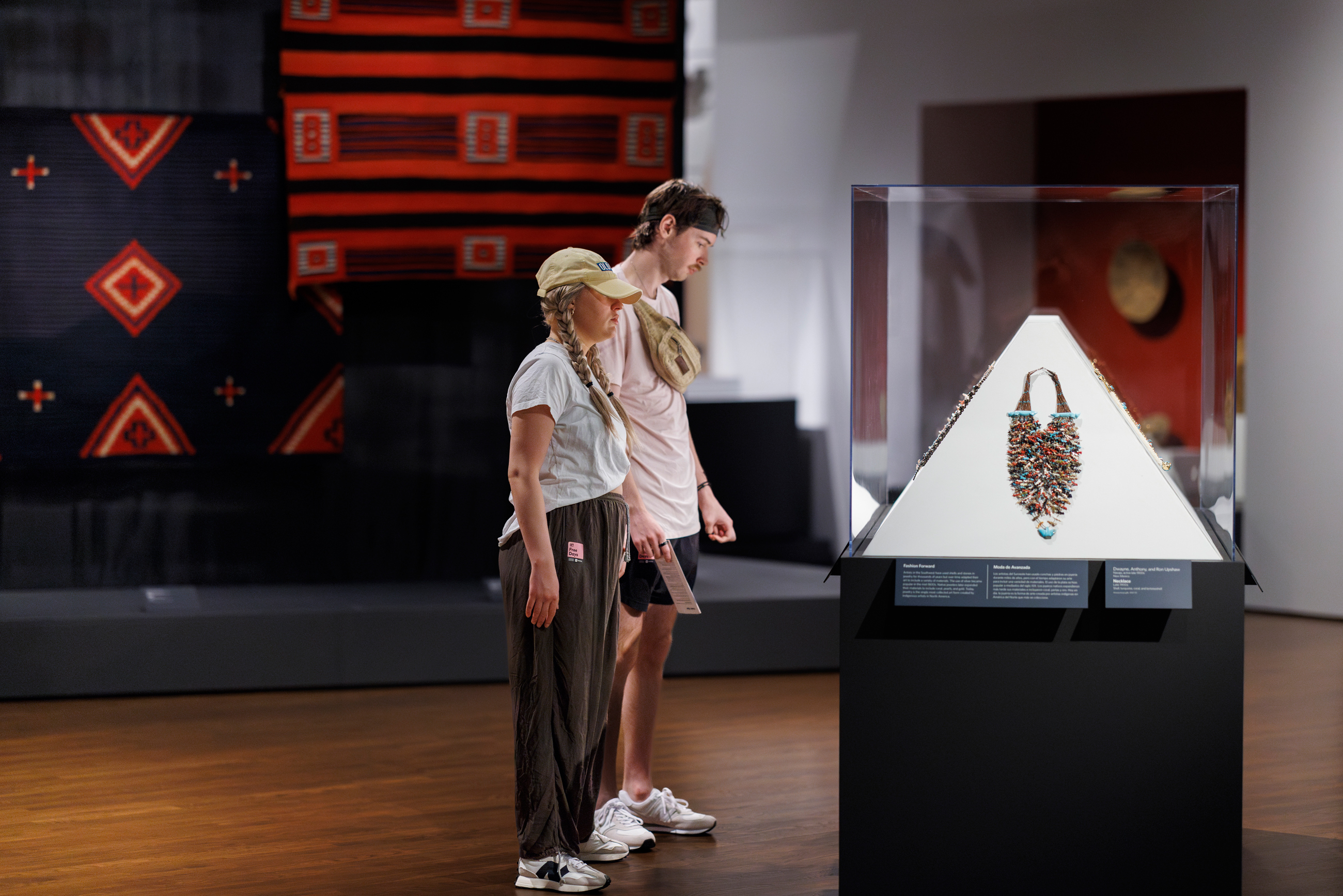 Two young adults looking at art encased in a glass display