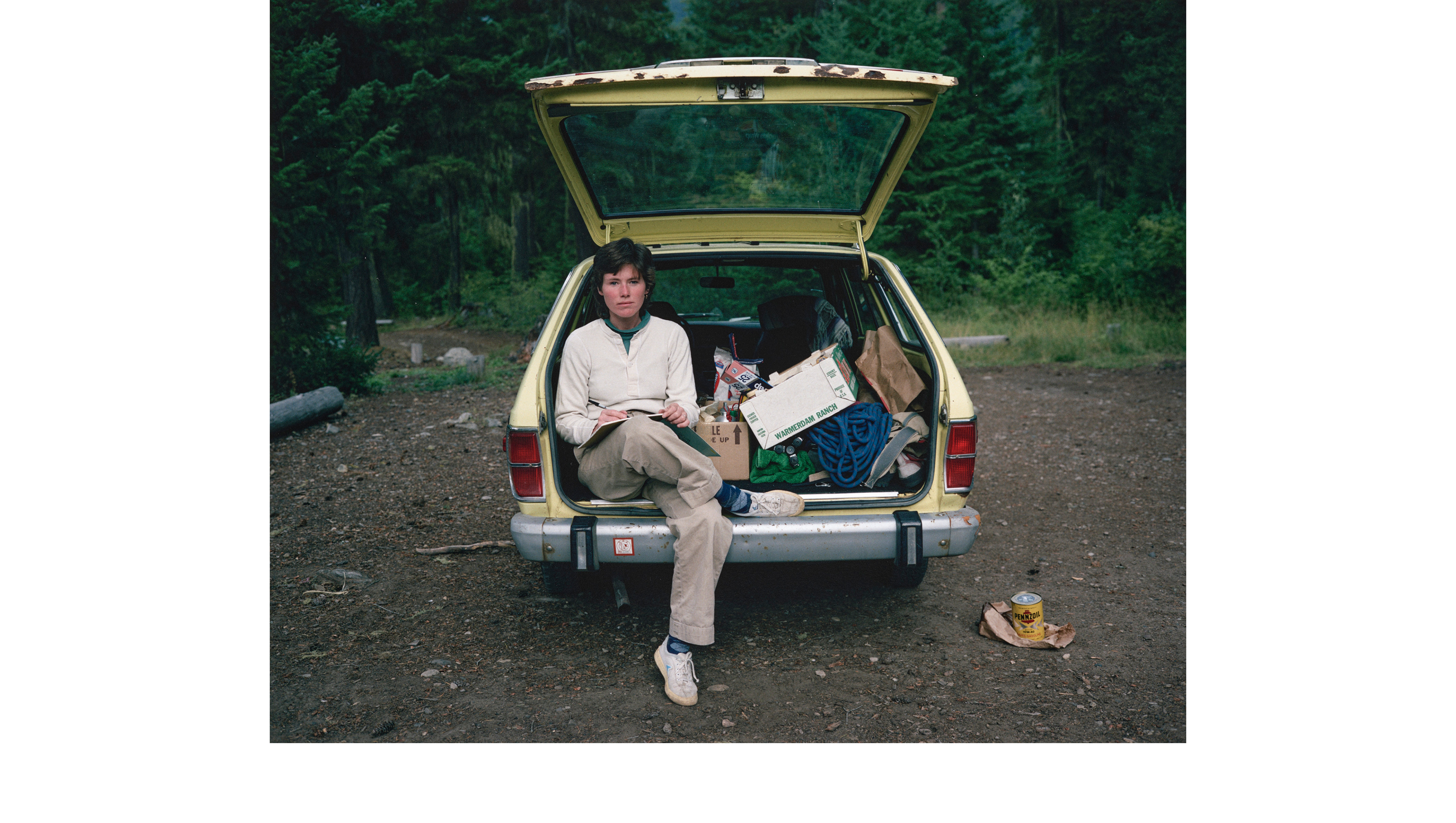 Woman sitting in the back of a car that's filled top-to-bottom with belongings
